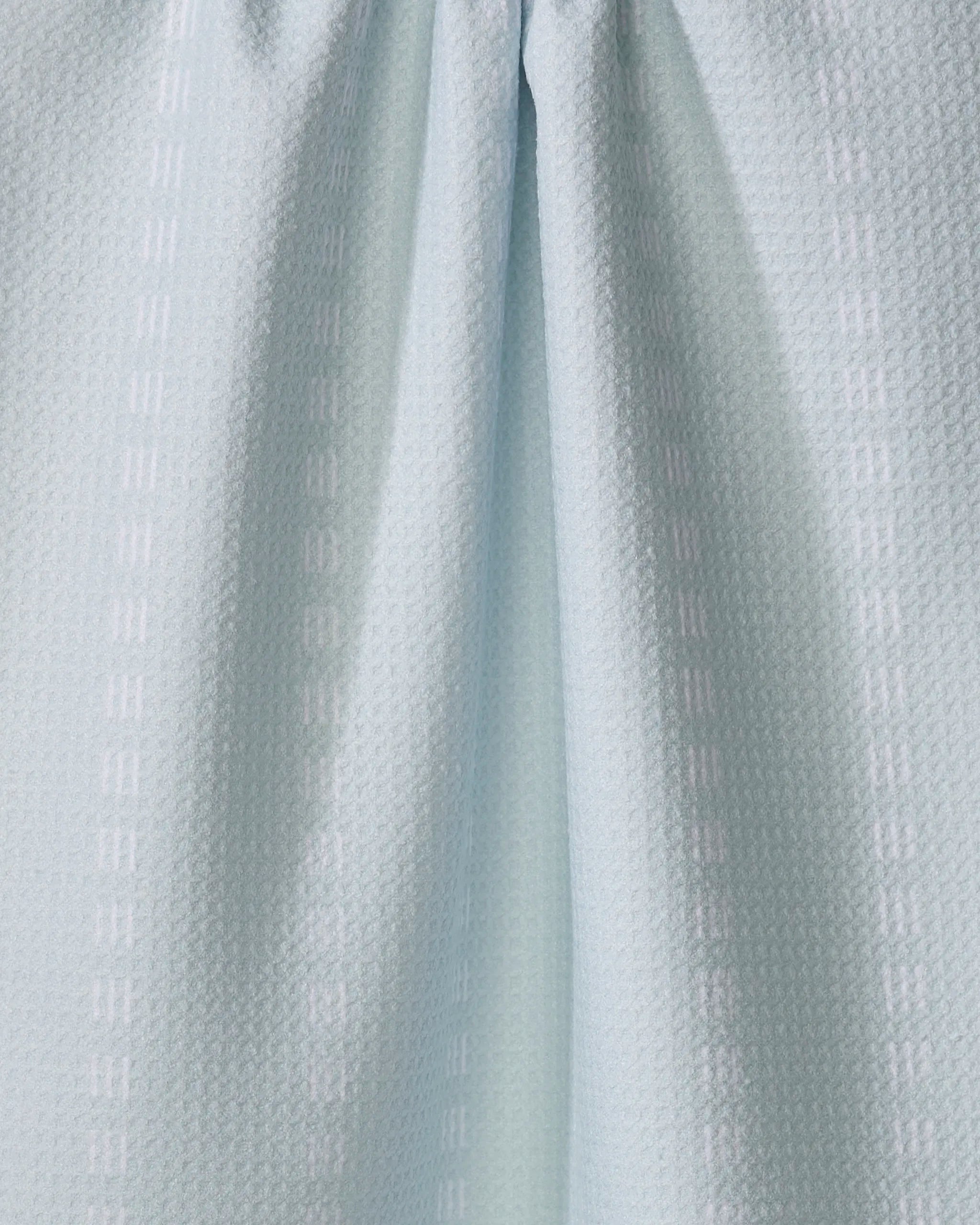 Close-up of The Buy Guide's Dashing - Mint kitchen towel, crafted from recycled materials with vertical rows of subtle raised rectangles and gentle center folds.