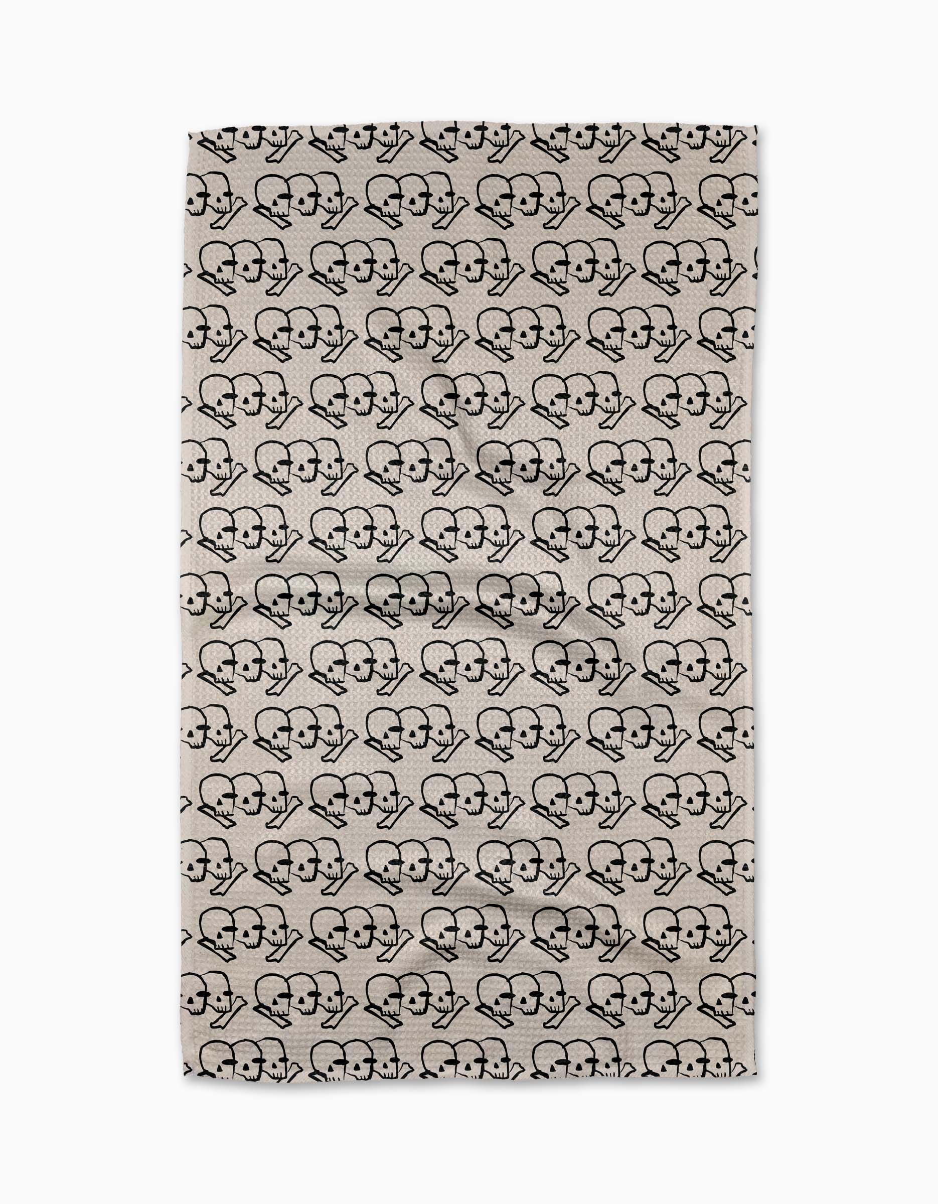 Cole Strems “Dead Set” is a beige rectangular rug with a black repeating pattern of two stylized skeletons side by side in heart shapes, inspired by the geometric designs from the Geometry Tea Towel collection.