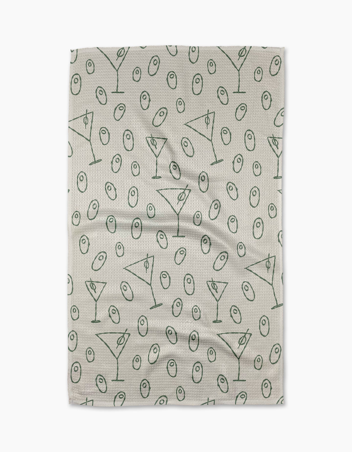 The Dirty Martini tea towel by Rosa Kichline showcases a beige textured background with a repeating pattern of green martini glasses and olives evenly scattered across the surface.