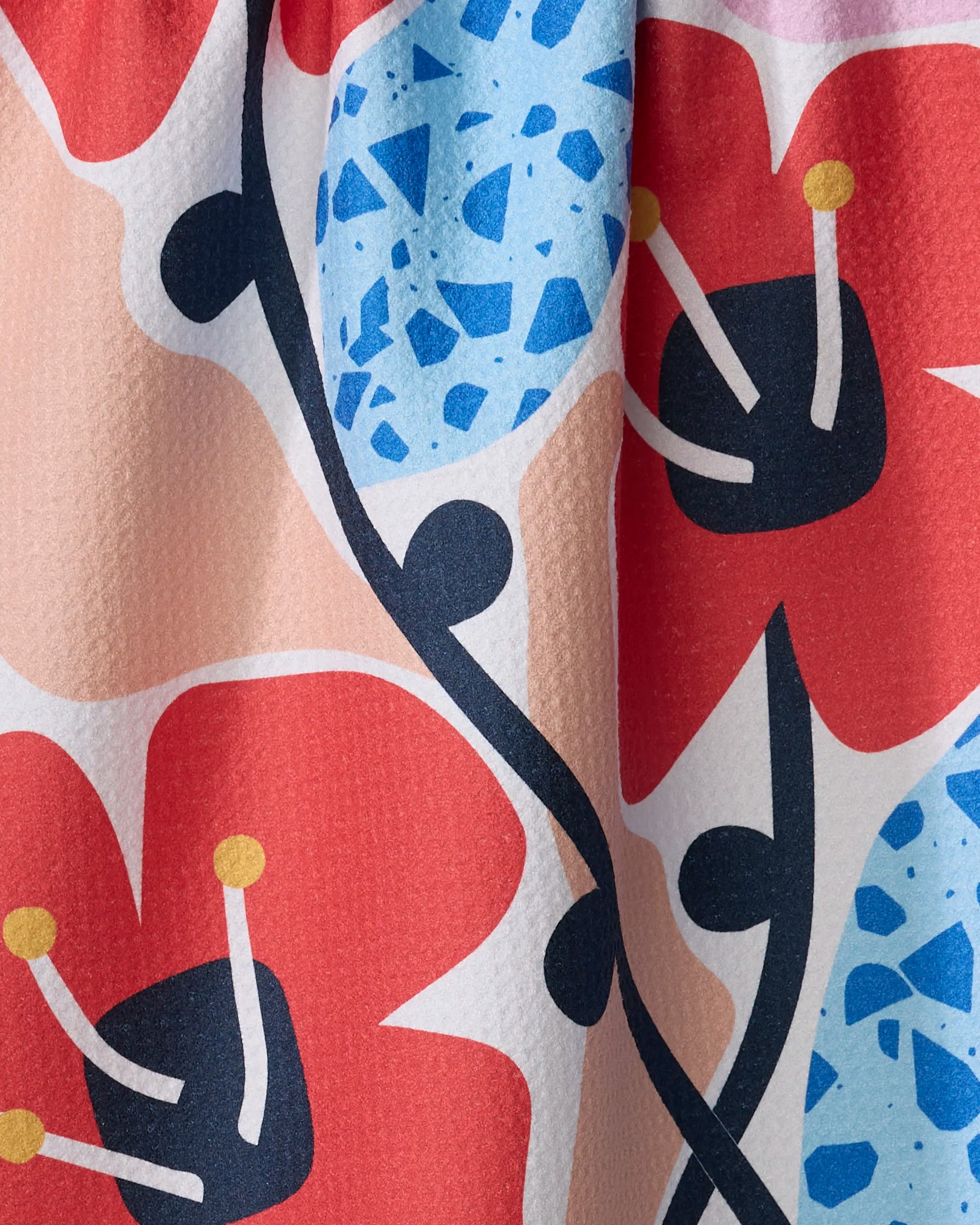 Close-up of the Dizzy Poppies recycled kitchen towel by Happy Hemera, showcasing a vibrant floral pattern with large red flowers, yellow stamens, blue accents, and black stems on a light background.