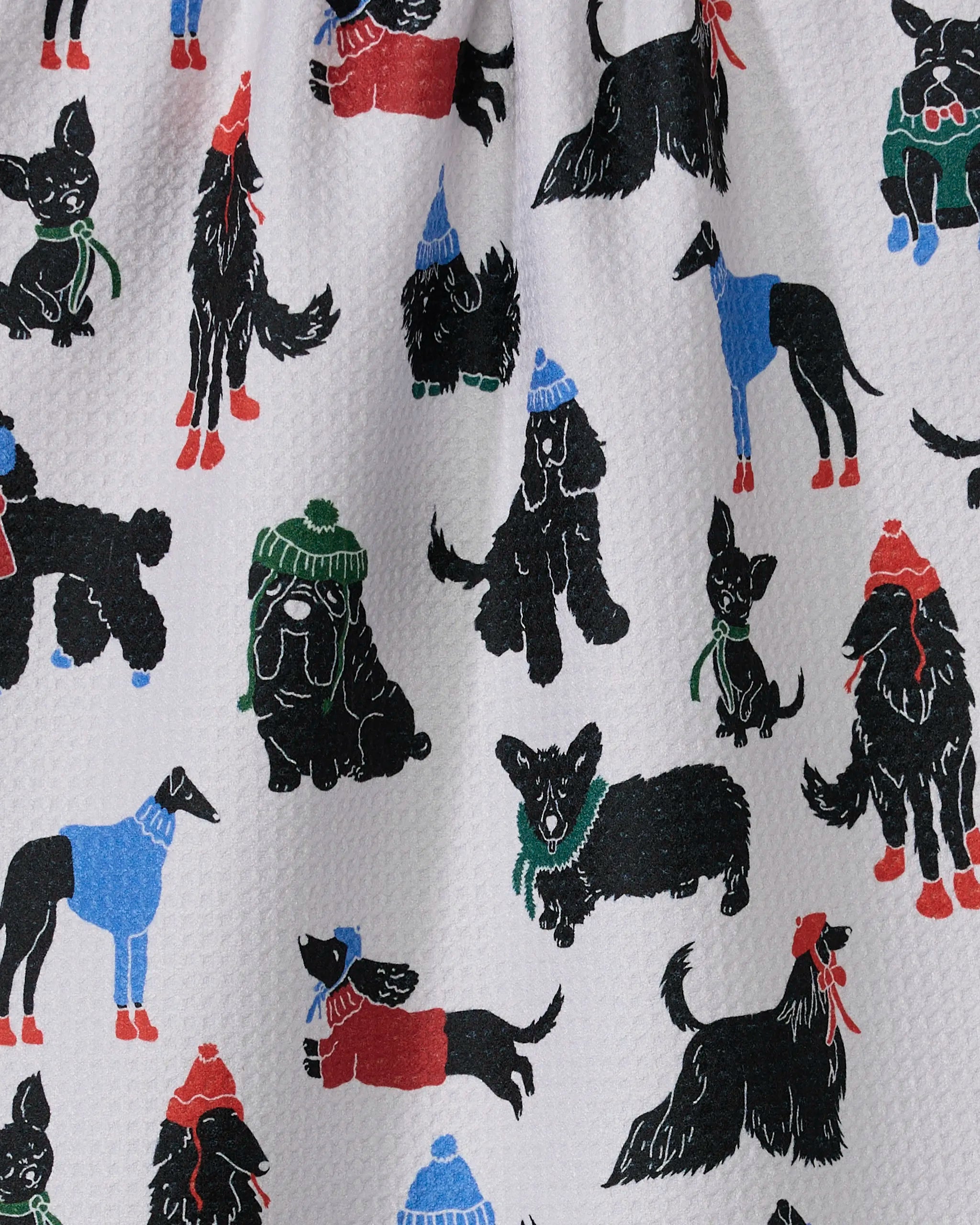 An illustration of dogs in colorful winter hats, sweaters, and scarves on white. This playful pattern features on Geometry’s Dogue Magazine tea towel, made from ultra-absorbent recycled materials—a festive addition to your kitchen.
