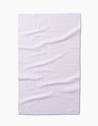 The Geometry Dot Dot Dot Blushed Bergamot is a white tea towel made from recycled materials, featuring a subtle light pink geometric pattern, shown flat and slightly wrinkled against a white background.