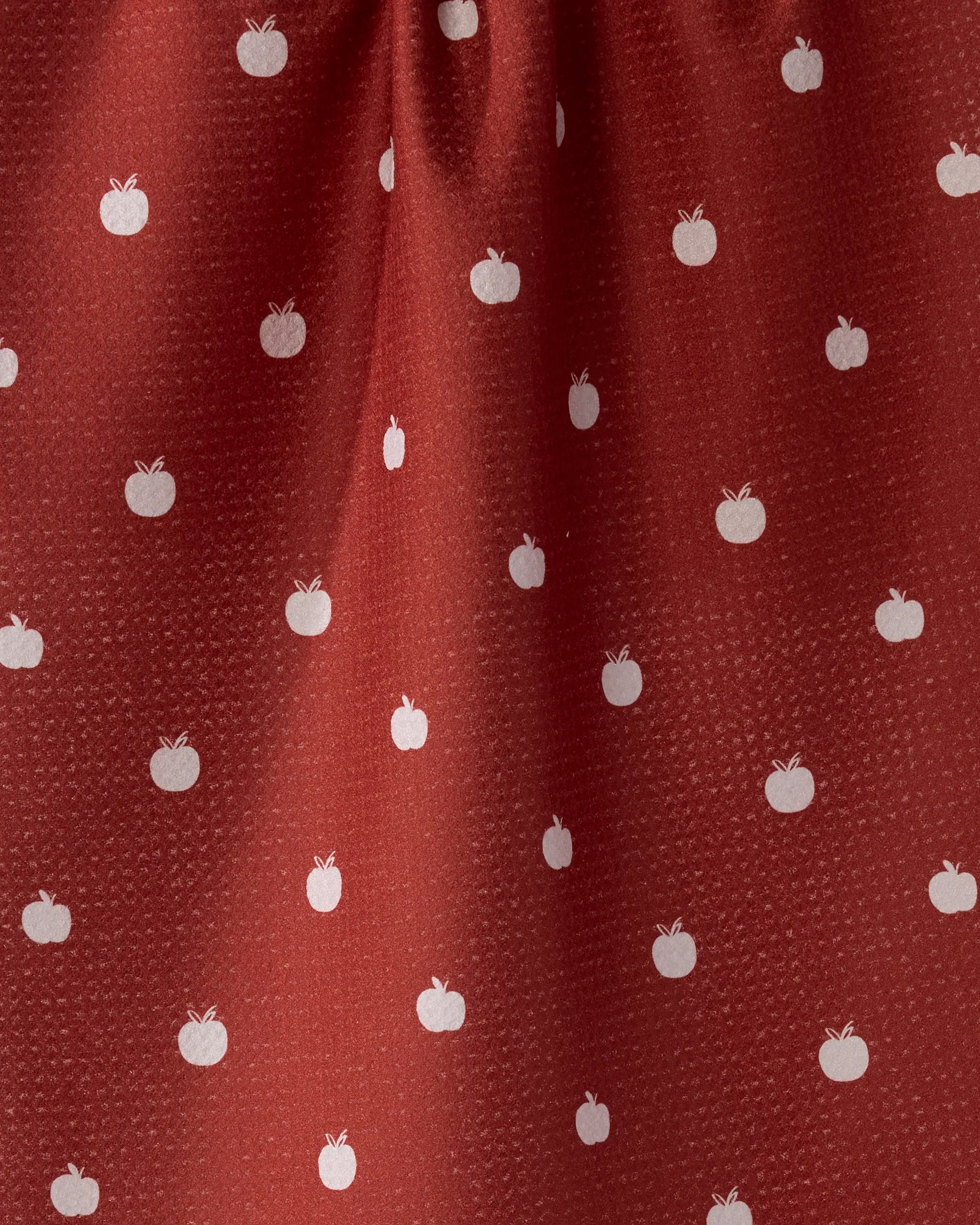 The Dotty Apple towel by Geometry features red fabric with a subtle dotted texture and evenly spaced small white apple icons. Ultra-absorbent with gentle folds at the top, it’s a charming addition to any kitchen tea towel collection.