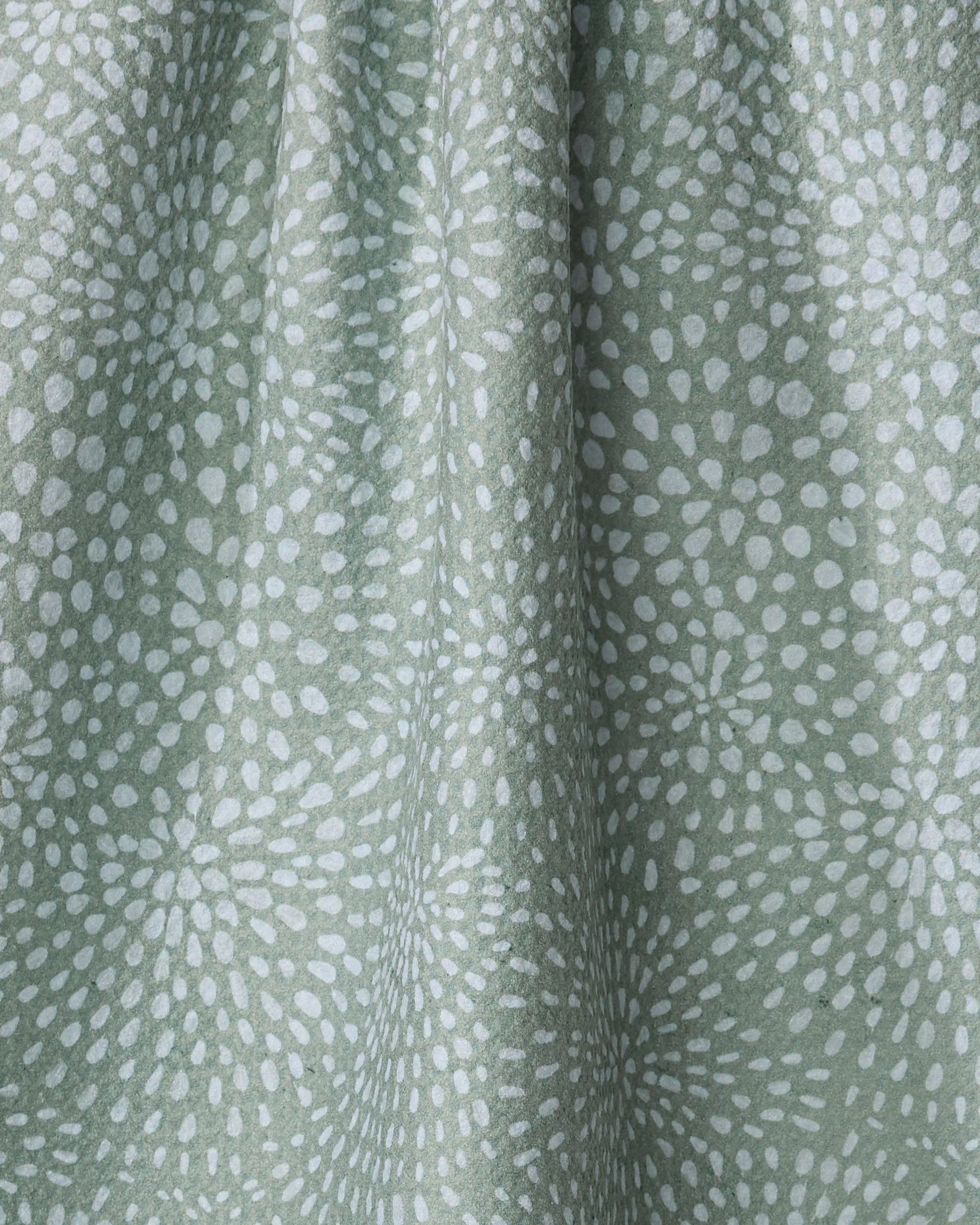 Droplets tea towel by Katie O'Shea: light green, made from recycled materials with a soft texture and a repeating pattern of white, abstract flower-like bursts.