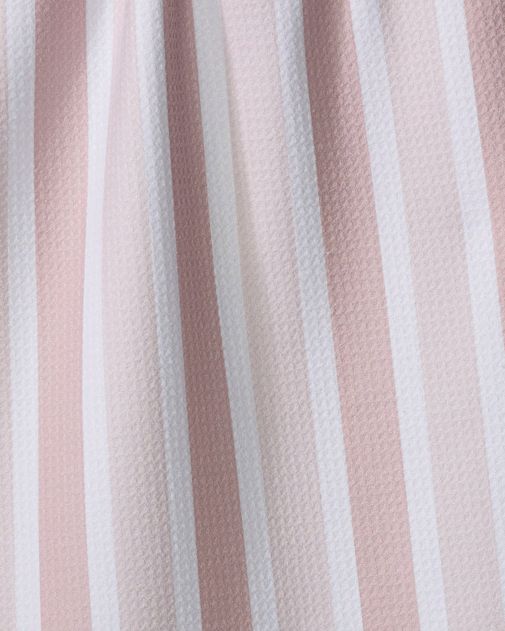 Close-up of The Buy Guide's "Earn Your Stripes - Dusty Rose" recycled kitchen towel, featuring gently varied vertical stripes in soft pink, beige, and white with a slightly textured finish.