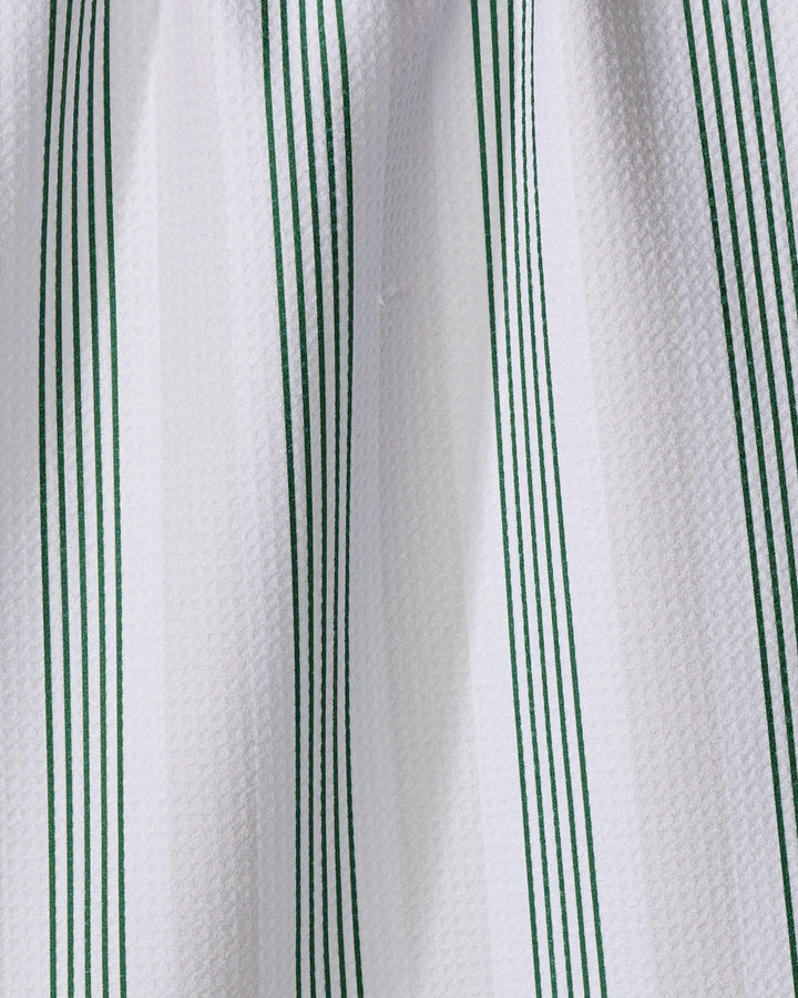 Close-up of The Buy Guide’s "Earn Your Stripes - Evergreen" tea towel, made from recycled materials, showcasing a white textured design with evenly spaced vertical green stripes in a repeating pattern.