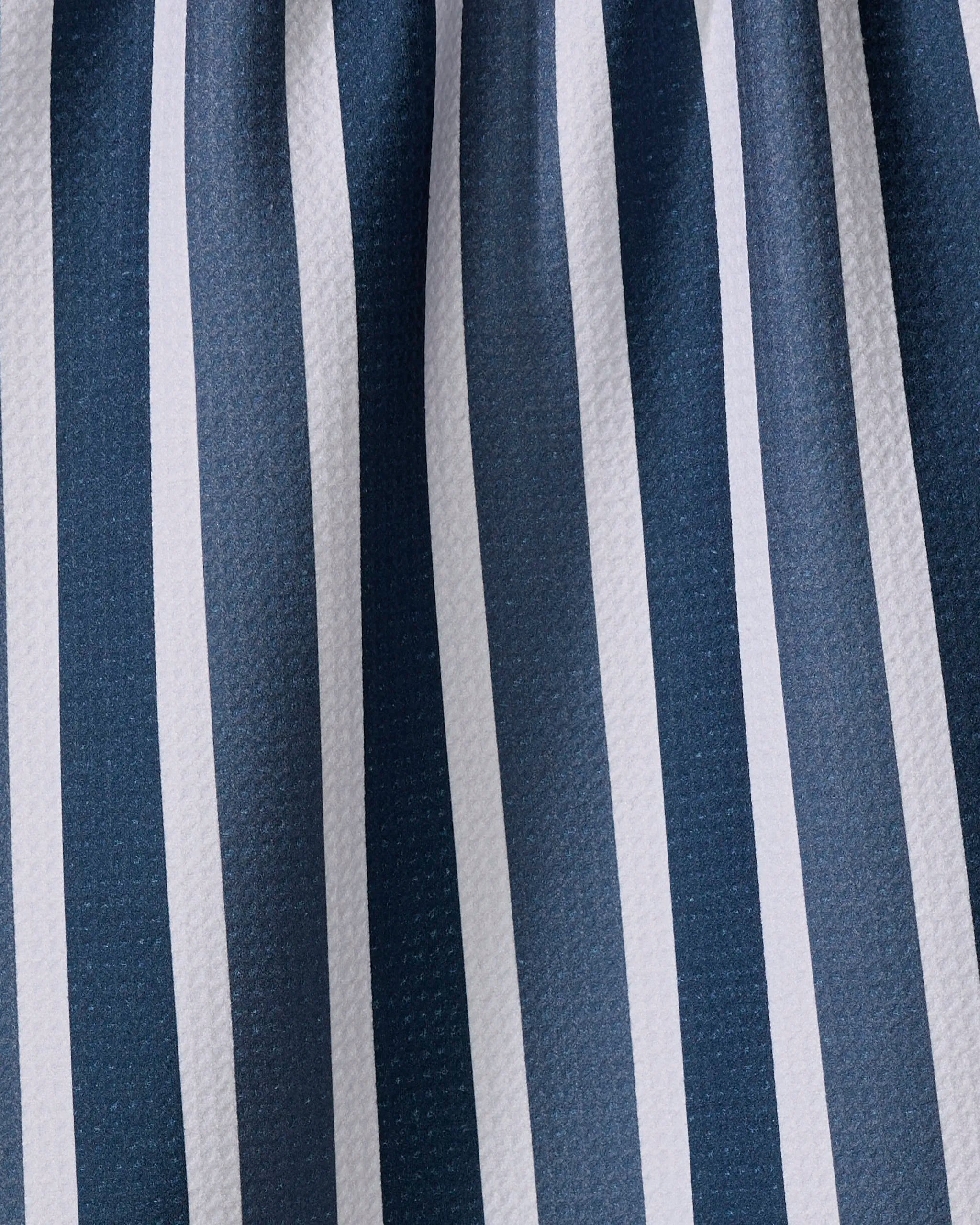 Close-up of The Buy Guide's Earn Your Stripes - Navy kitchen towel, featuring vertical navy blue and white stripes, a subtle sheen, and gentle folds that add depth and texture.