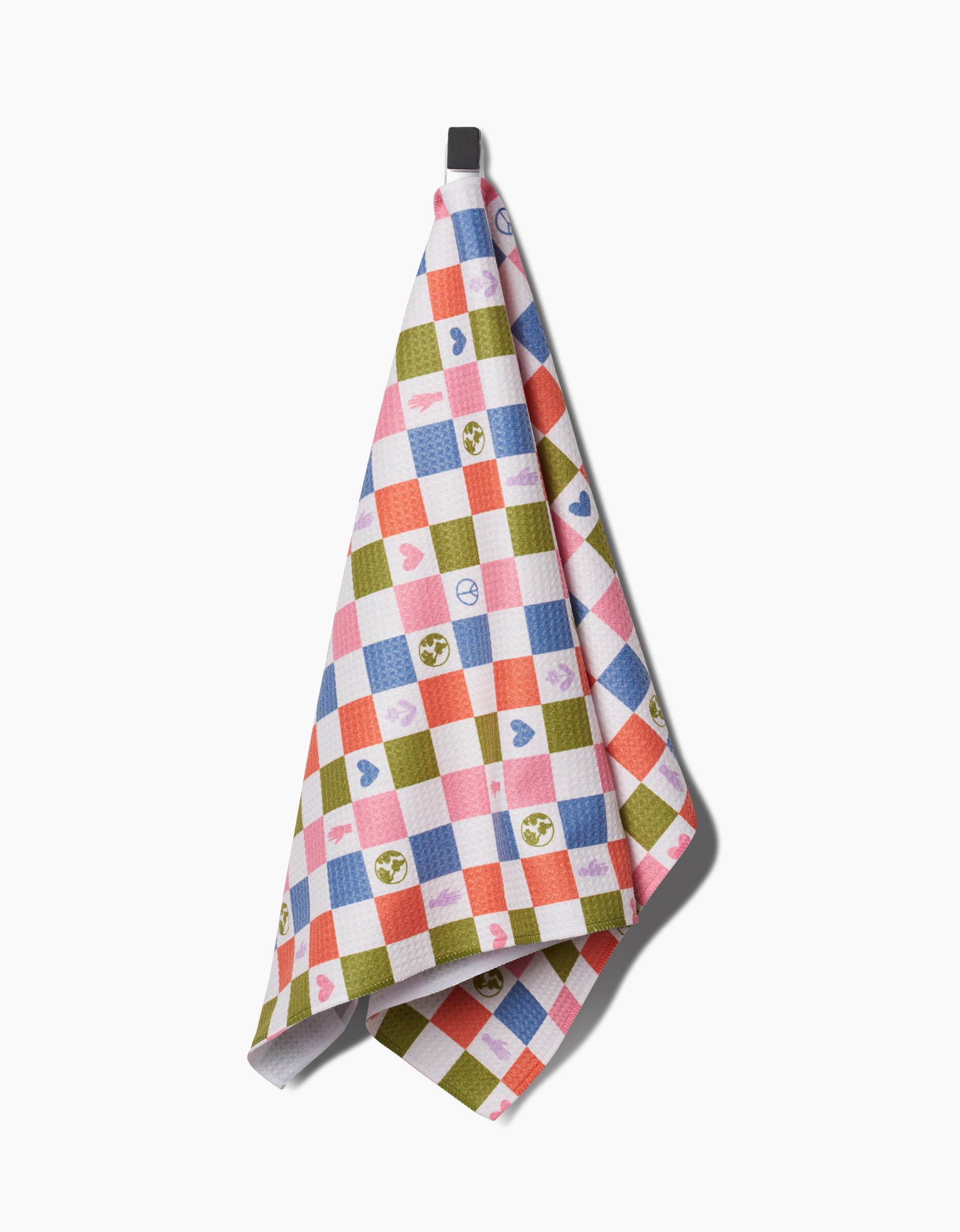 The Kayla Ann Earth Day Checkers kitchen tea towel features a colorful red, blue, green, and white checkered pattern with hearts and smiley faces, hanging from a black loop against a white background.