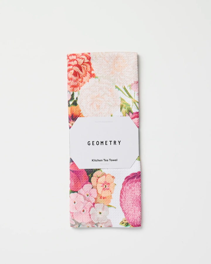 A folded, ultra-absorbent Geometry kitchen tea towel in the Ecstatic Blooms floral print, made from recycled materials, wrapped with a white label and displayed on a plain white background.