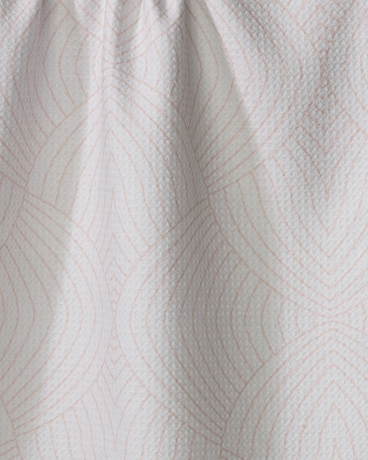 The Eileen tea towel by Amy MacCready is made from recycled materials and features a subtle geometric pattern of overlapping pink lines, with slight gathering at the top for added texture.