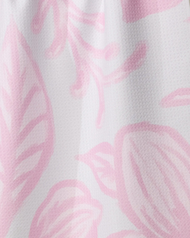 Close-up of the Elsie tea towel by Geometry, featuring a light pink abstract floral and leaf pattern on white. Made from recycled materials, its fabric is visibly textured for added style and function.