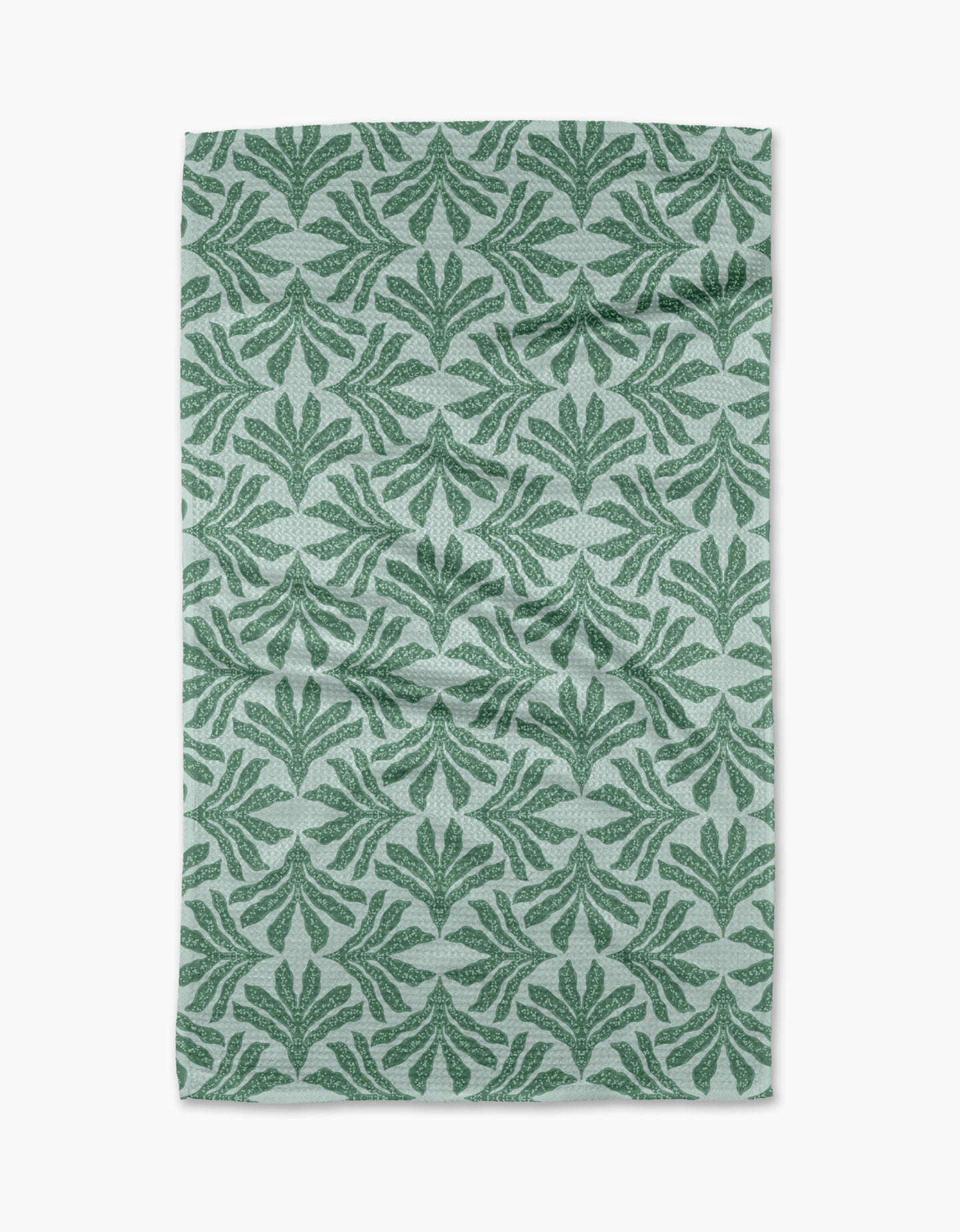 The Ethereal Seaweeds tea towel by Jasmine Blooms Designs features a green leafy pattern on light gray recycled fabric with symmetrical stylized leaf motifs. The slightly wrinkled towel is displayed against a white background.