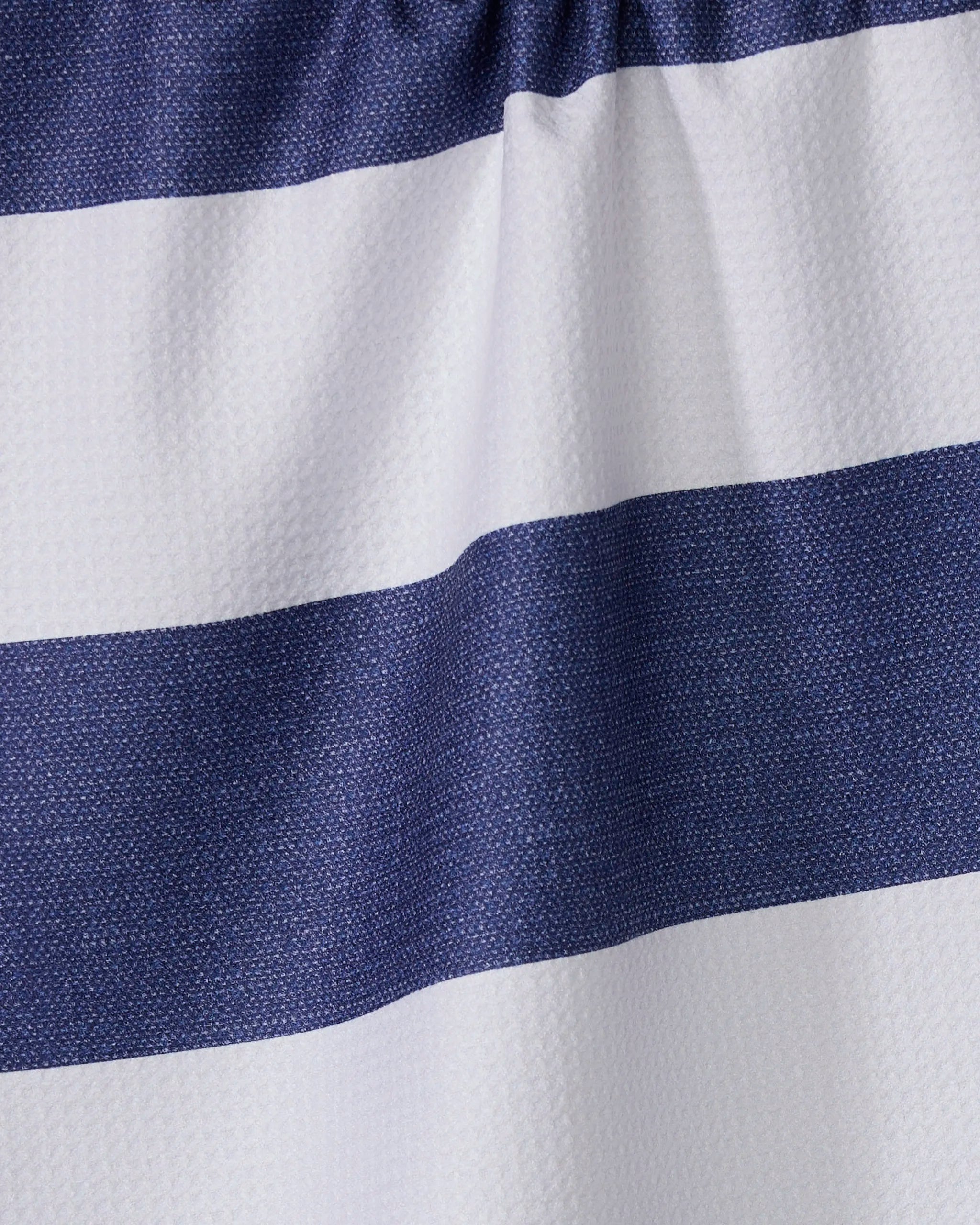Close-up of the Geometry Everband kitchen towel, featuring wide horizontal navy blue and white stripes. The textured, wavy surface with gentle folds highlights its sustainable, recycled material construction.