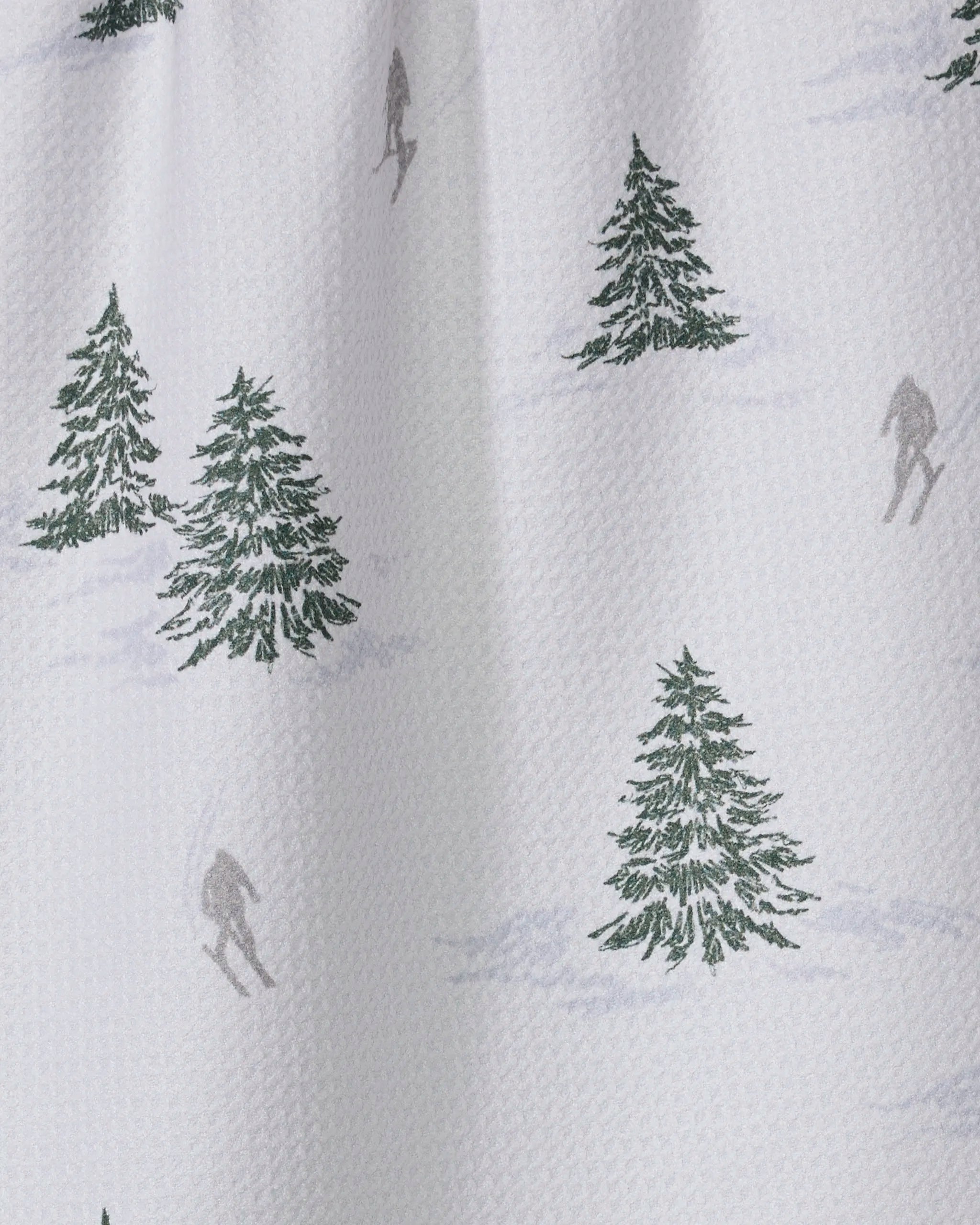Evermont by Geometry: a white textured tea towel made from recycled fabric, featuring green pine trees and gray skiers. Ultra-absorbent—ideal for your kitchen.