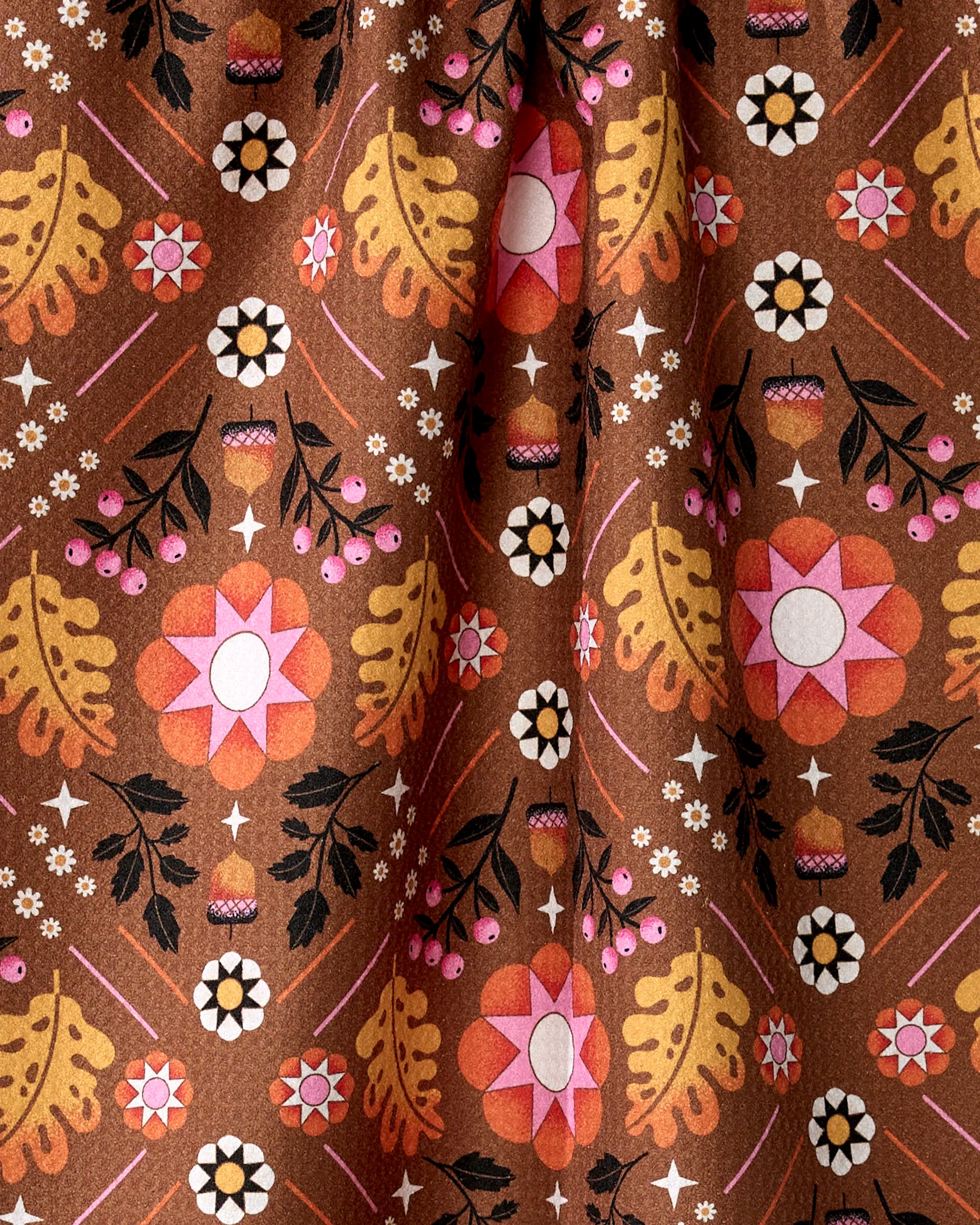 The Fall Folk tea towel by Megan Roy features a brown fabric with large pink and white retro flowers, yellow leaves, and bold accents—crafted from recycled materials for ultra-absorbency.