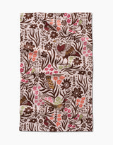 The Kayla Ann Fall Fowl tea towel is rectangular and made from recycled materials, featuring a floral and bird pattern in brown, green, and pink on a cream background. The fabric has a slightly wrinkled texture.