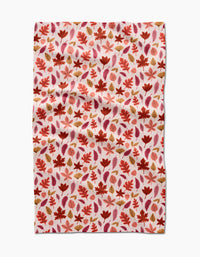 The Fall Leaves tea towel by Kayla Ann features a red, orange, and brown autumn leaf pattern on white. This absorbent, slightly wrinkled cloth is perfect for adding eco-friendly charm to your kitchen décor.