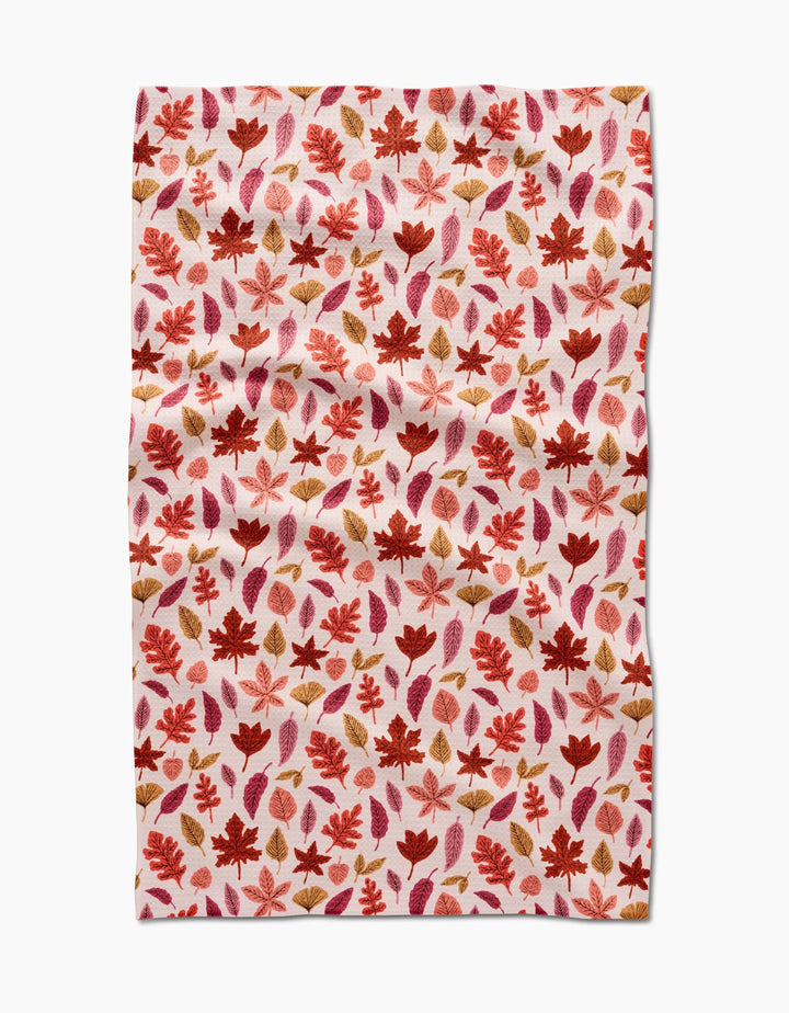The Fall Leaves tea towel by Kayla Ann features a red, orange, and brown autumn leaf pattern on white. This absorbent, slightly wrinkled cloth is perfect for adding eco-friendly charm to your kitchen décor.