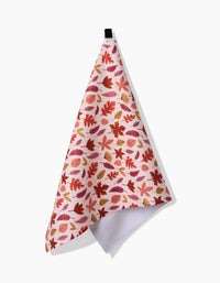 The Kayla Ann Fall Leaves dish towel features an absorbent fabric and a vibrant red, orange, and gold autumn leaf print, displayed with a black hanging loop on a white background.