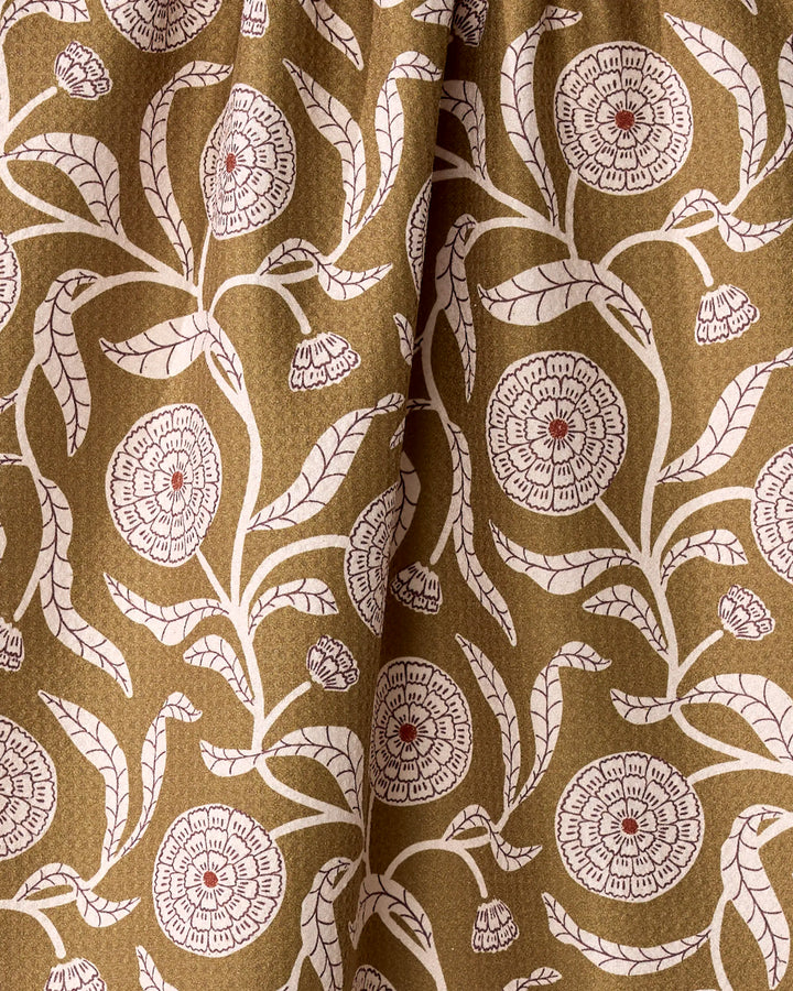 The Falling Flowers dish towel by Teri the Butter features brown fabric with a vintage-inspired white floral pattern, red-centered blooms, and textured folds—an absorbent towel perfect for display or daily use.
