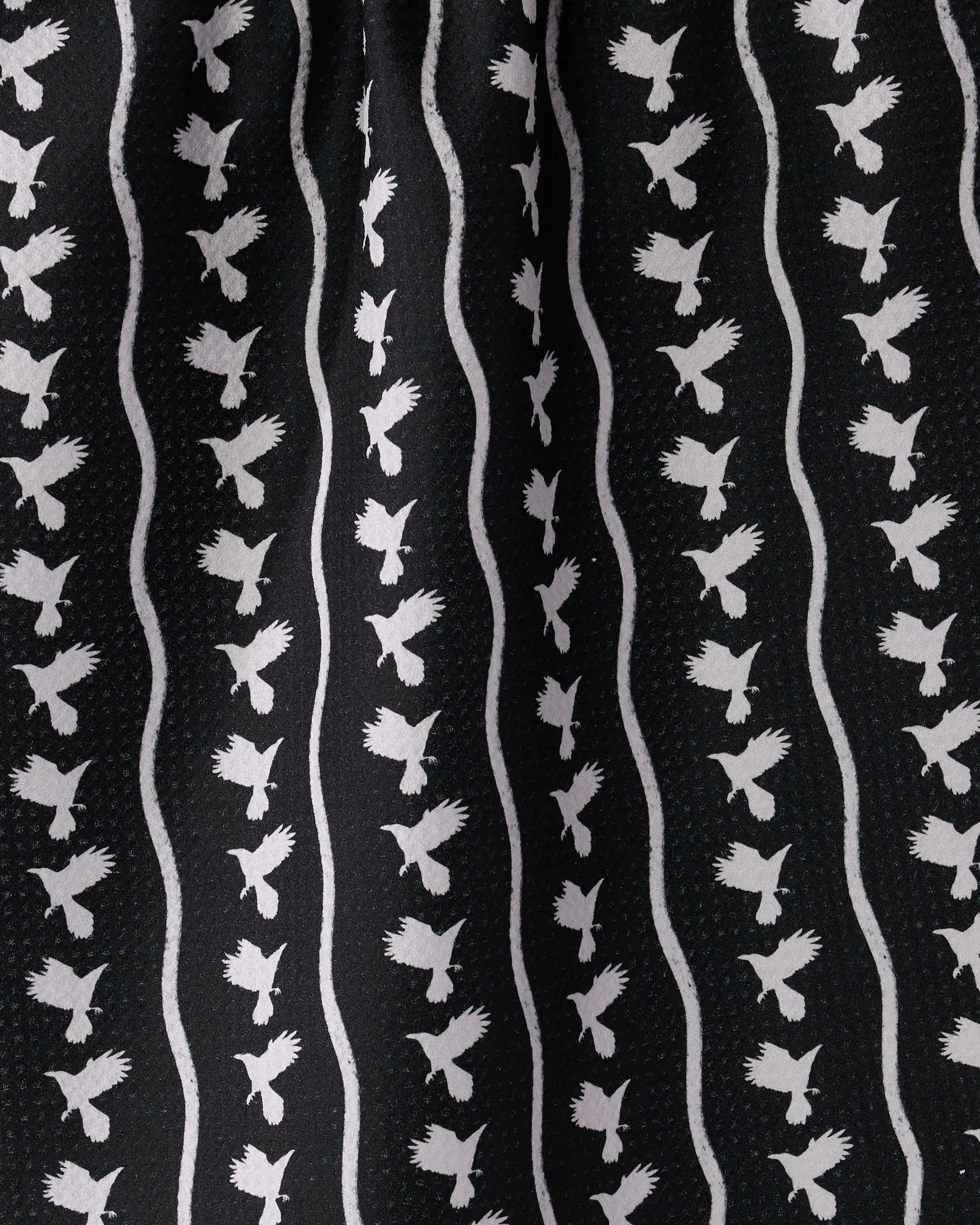 The Geometry Featherline towel features black fabric with rows of white bird silhouettes in flight, separated by wavy lines. Ultra-absorbent and stylish, it’s the perfect tea towel to enhance your kitchen décor.