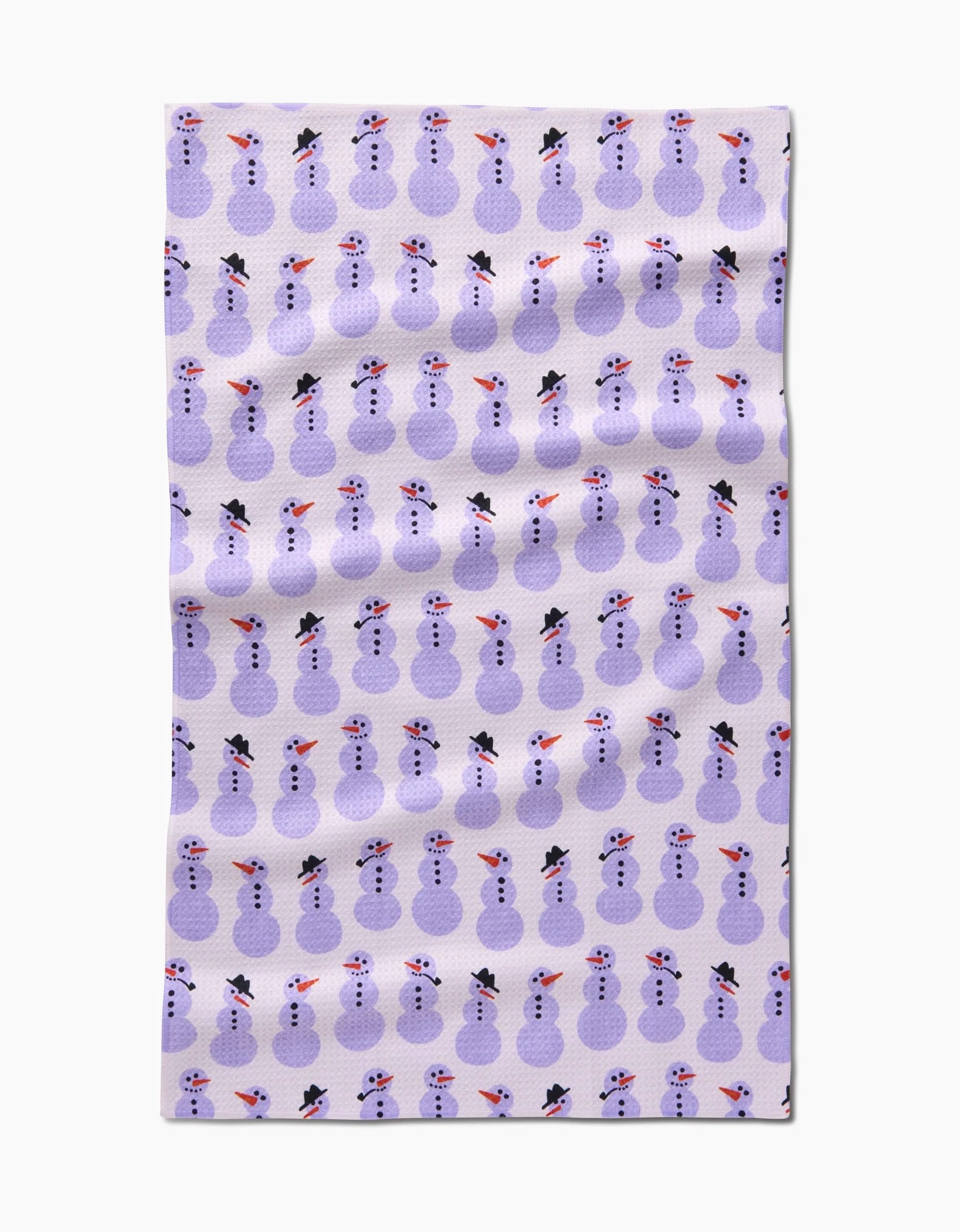 The Felicity Purple tea towel by Amy MacCready is a rectangular, eco-friendly piece featuring neat rows of purple snowmen in black hats and red scarves on a white background.