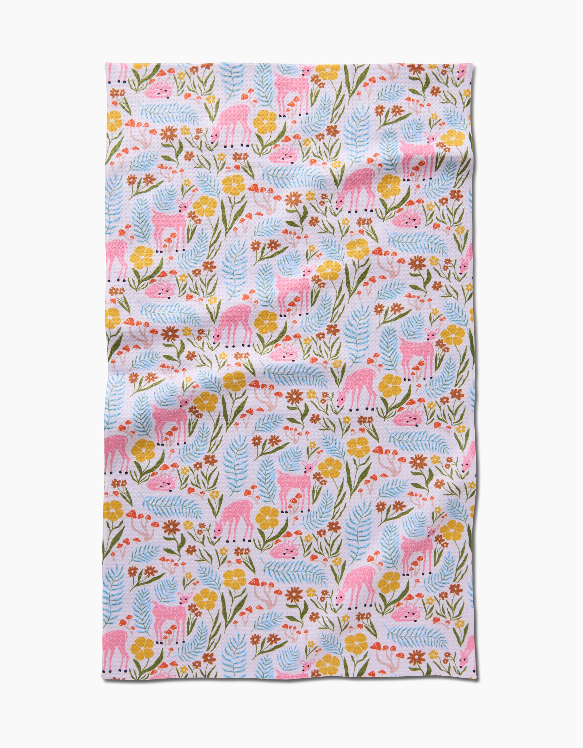 The Fern and Fawn tea towel by Kayla Ann features playful pink deer, yellow flowers, and green leaves on white. Made from recycled materials, it has a slightly wrinkled look and a whimsical, nature-inspired design.