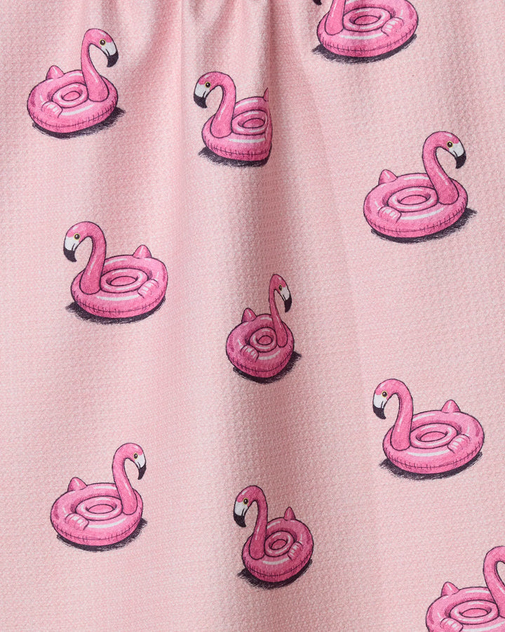 Close-up of Geometry's Flamingo Floatie: a pink textured fabric patterned with repeating pink flamingo pool floats, each facing different directions—an ideal playful kitchen towel made from recycled materials.