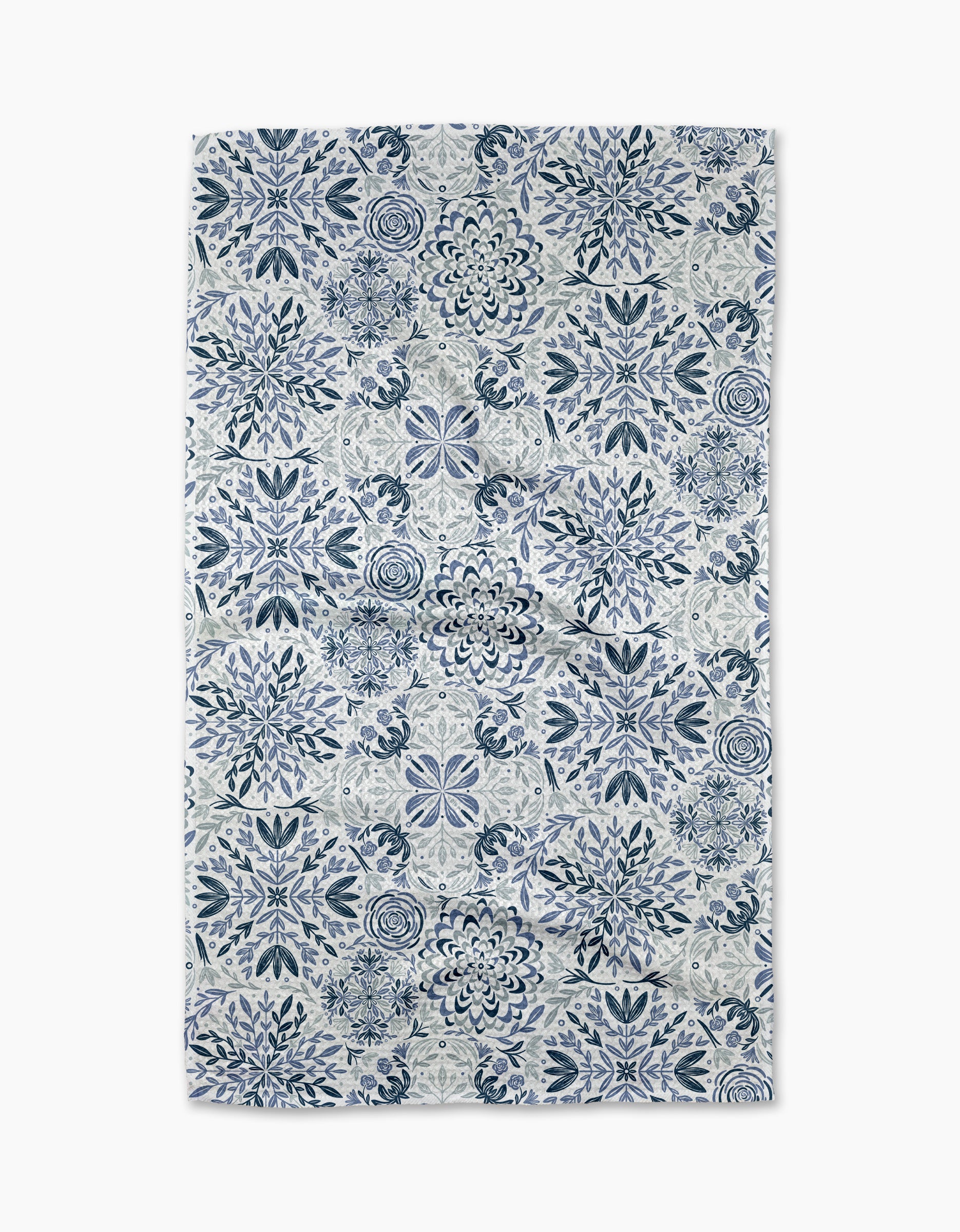 The Floral Medallions tea towel by Sarah Daugherty features a symmetrical blue and white floral and geometric tile-inspired pattern on a crisp white background.