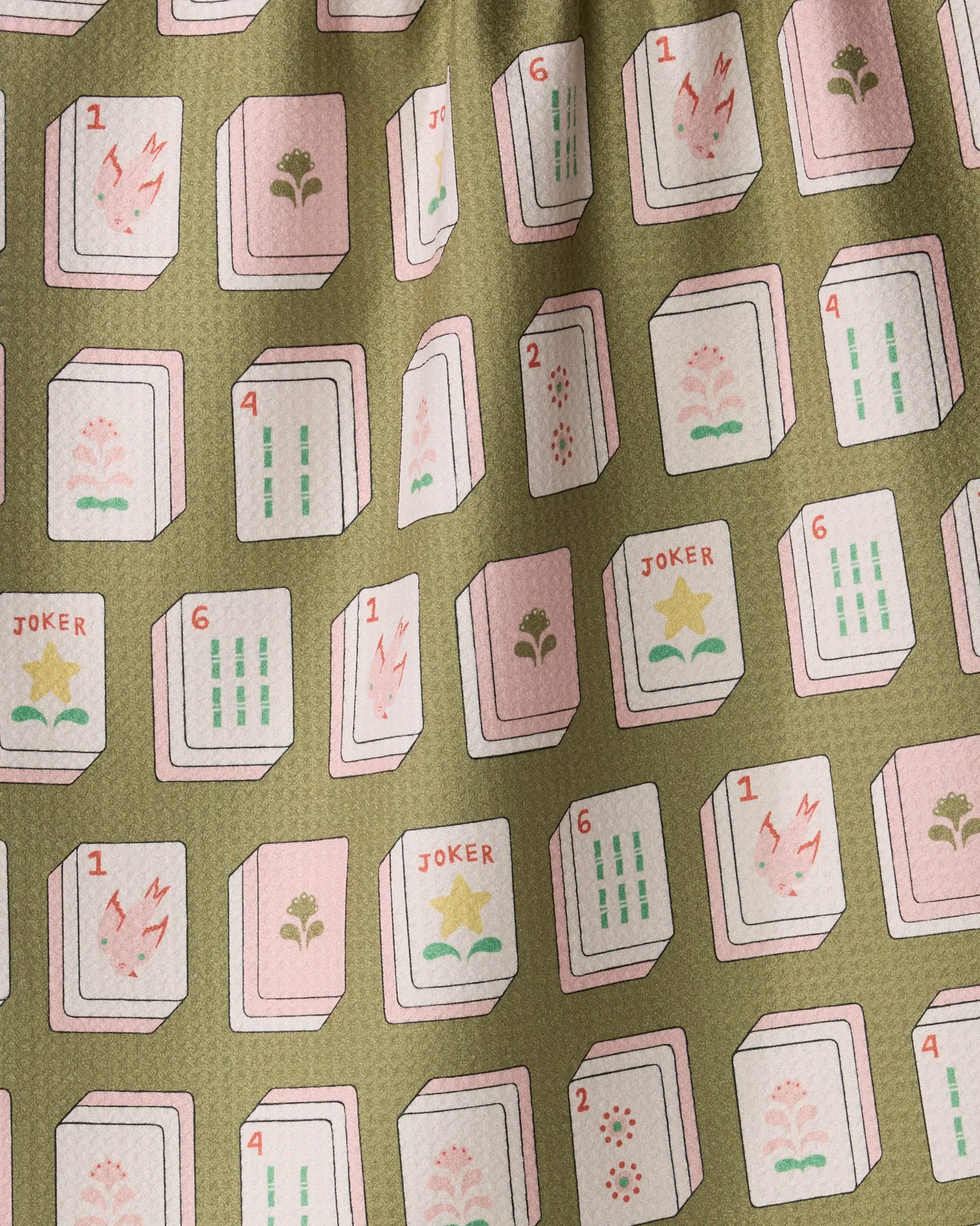 The “Flower Tiles” tea towel by Geometry features a vibrant pattern of pink and green Mahjong tiles—including Jokers, numbers, and flowers—arranged in a repeating grid on a textured olive-green background. This eco-friendly kitchen towel not only adds visual interest to your space but is also quick-drying and perfect for everyday use.