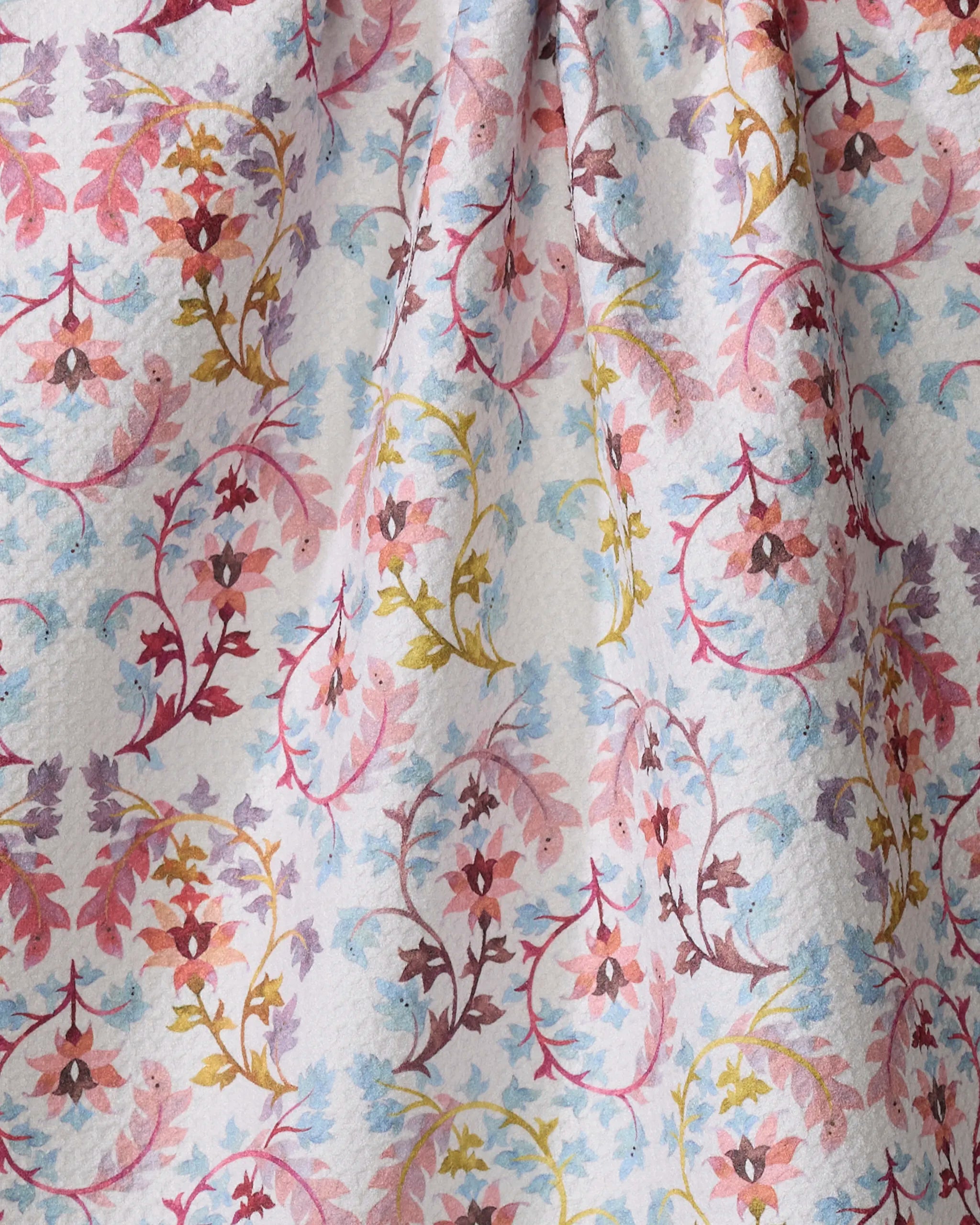 A close-up of Maayan Alper-Swan's Folk Tapestry fabric shows a colorful floral and vine pattern in pink, yellow, blue, and purple on white—ideal for an eco-friendly kitchen towel.