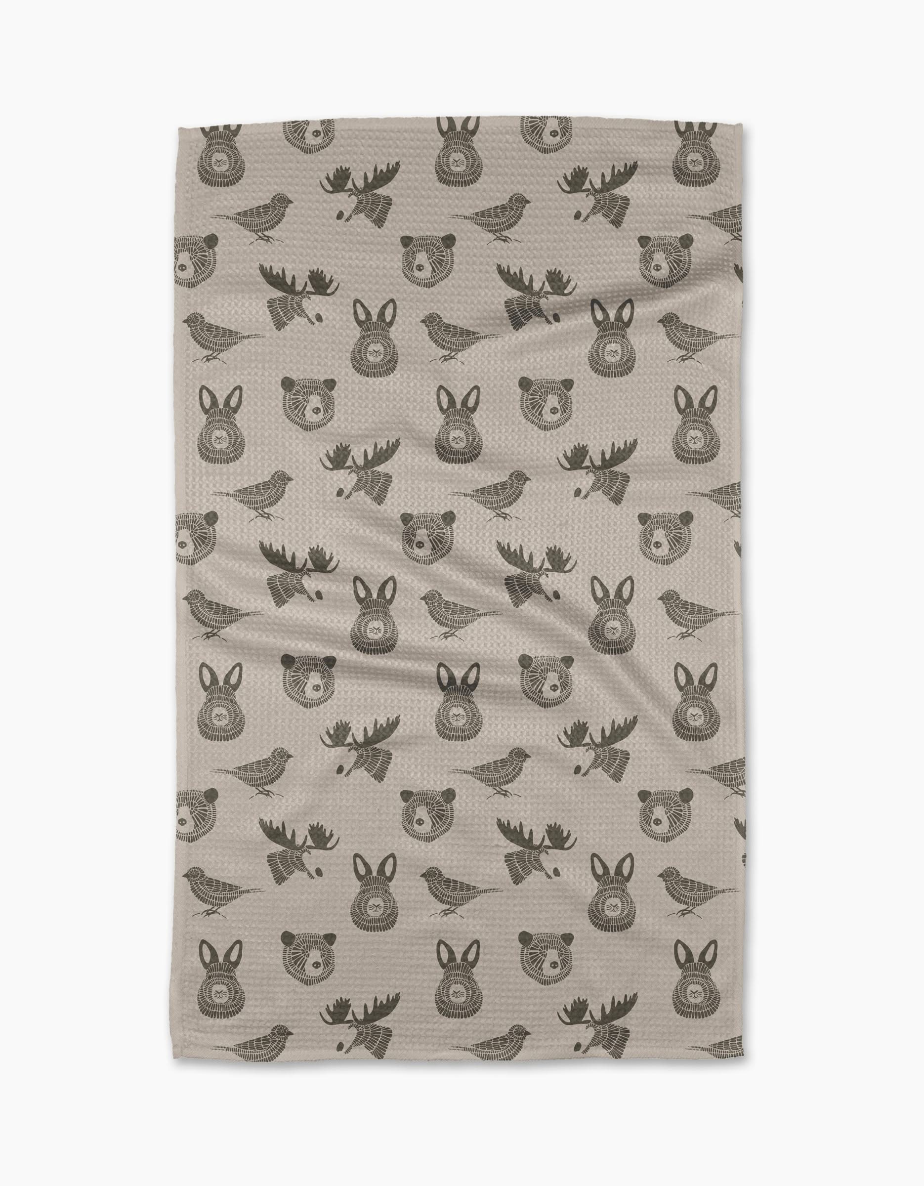 The Forest Animals tea towel by Rosa Kichline features beige fabric with a repeating pattern of simple, dark brown cartoon-style bears, moose, rabbits, and birds. Quick-drying and practical, it brings charm to any kitchen.