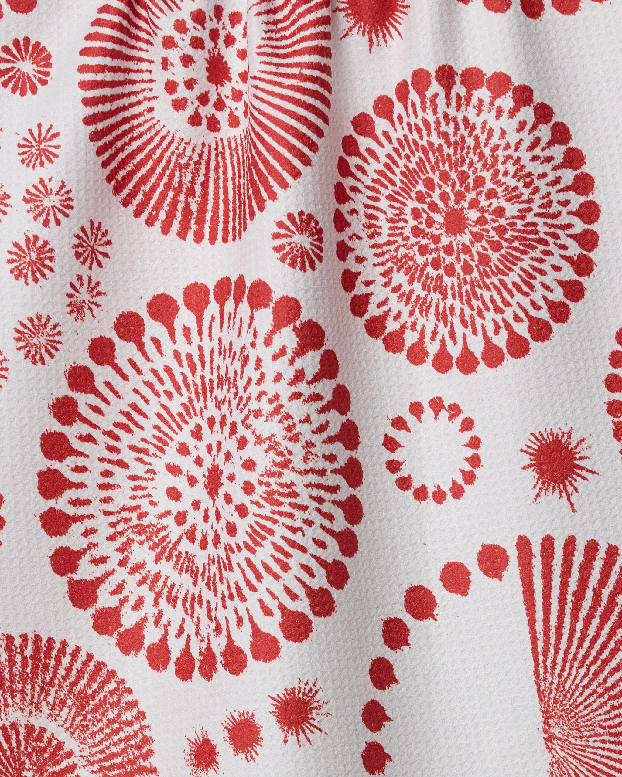 Freedom Sparks by Geometry features red circular designs—like bursts of fireworks or sea urchins—printed on a white textured, quick-drying towel. Its radiating lines and dots make it a stylish tea towel for your kitchen.
