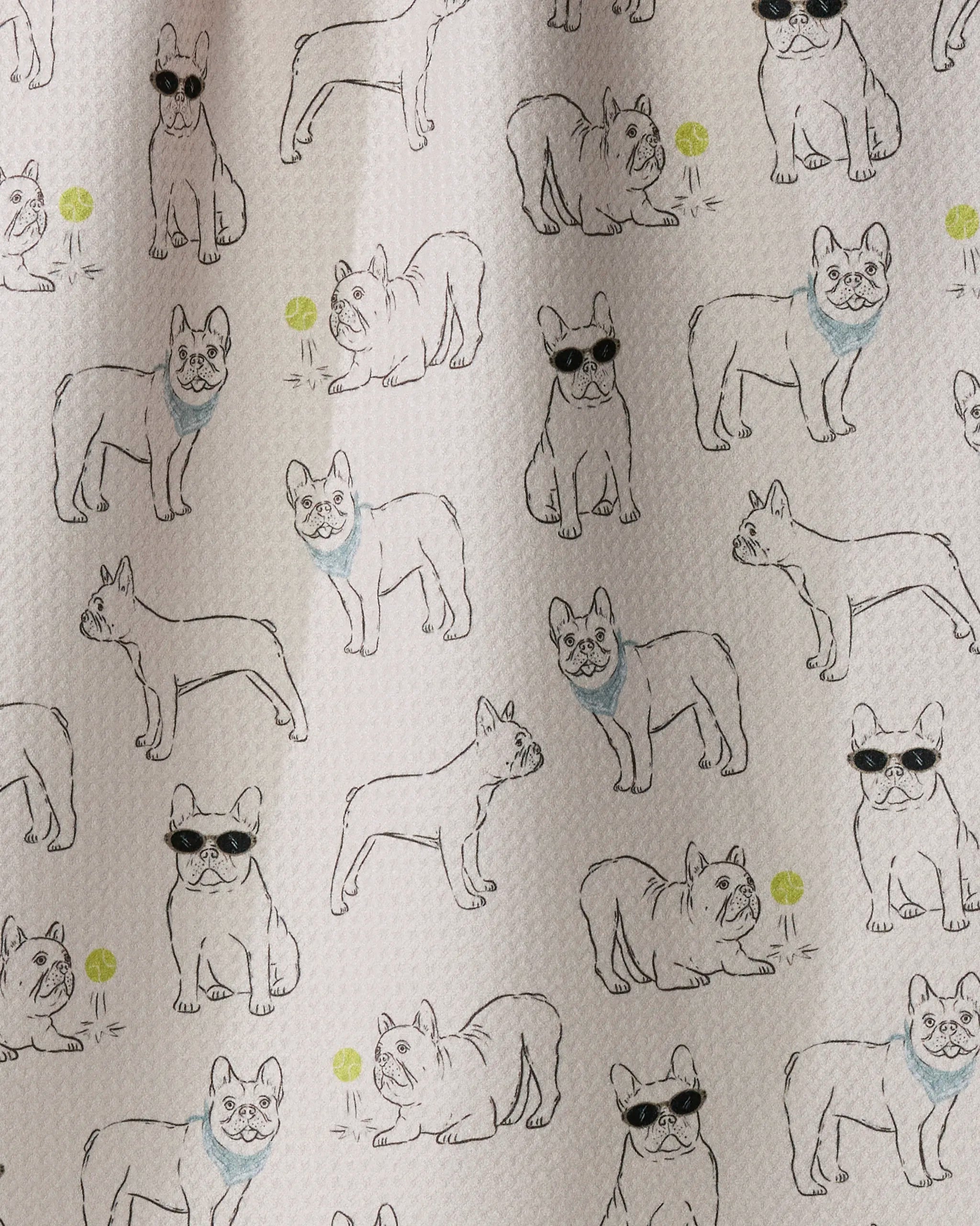 Frenchie Frolic by Geometry features patterned fabric adorned with line drawings of French bulldogs in various poses—some sporting sunglasses or blue scarves—with green balls scattered across a light background, making it perfect for creating playful tea towels from recycled materials.