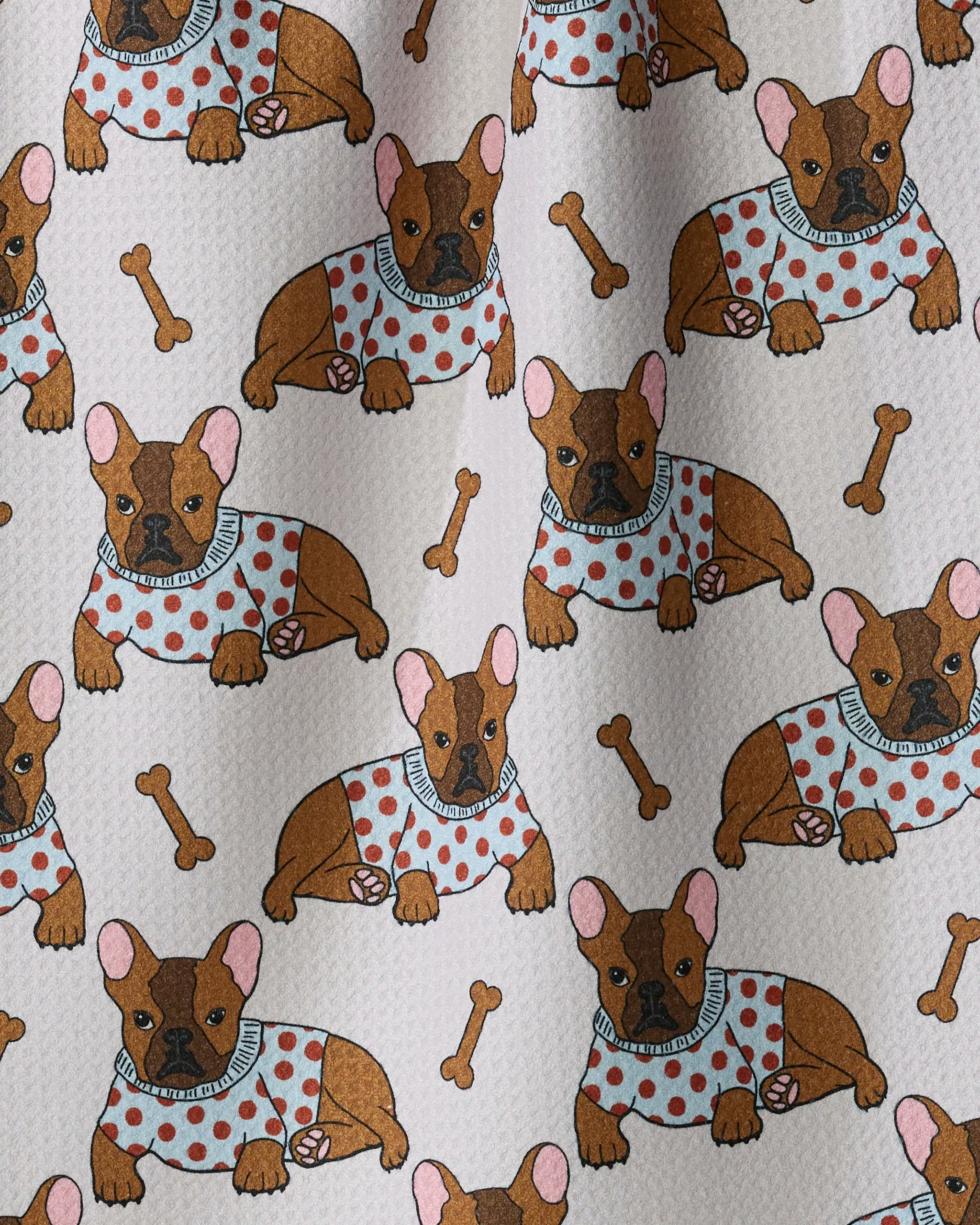 Add a playful touch to your kitchen décor with Geometry’s Frenchie Fun dish towel—featuring a patterned fabric of brown French bulldogs in polka dot sweaters, scattered bones, and a textured cream background. This absorbent towel is as charming as it is functional!.