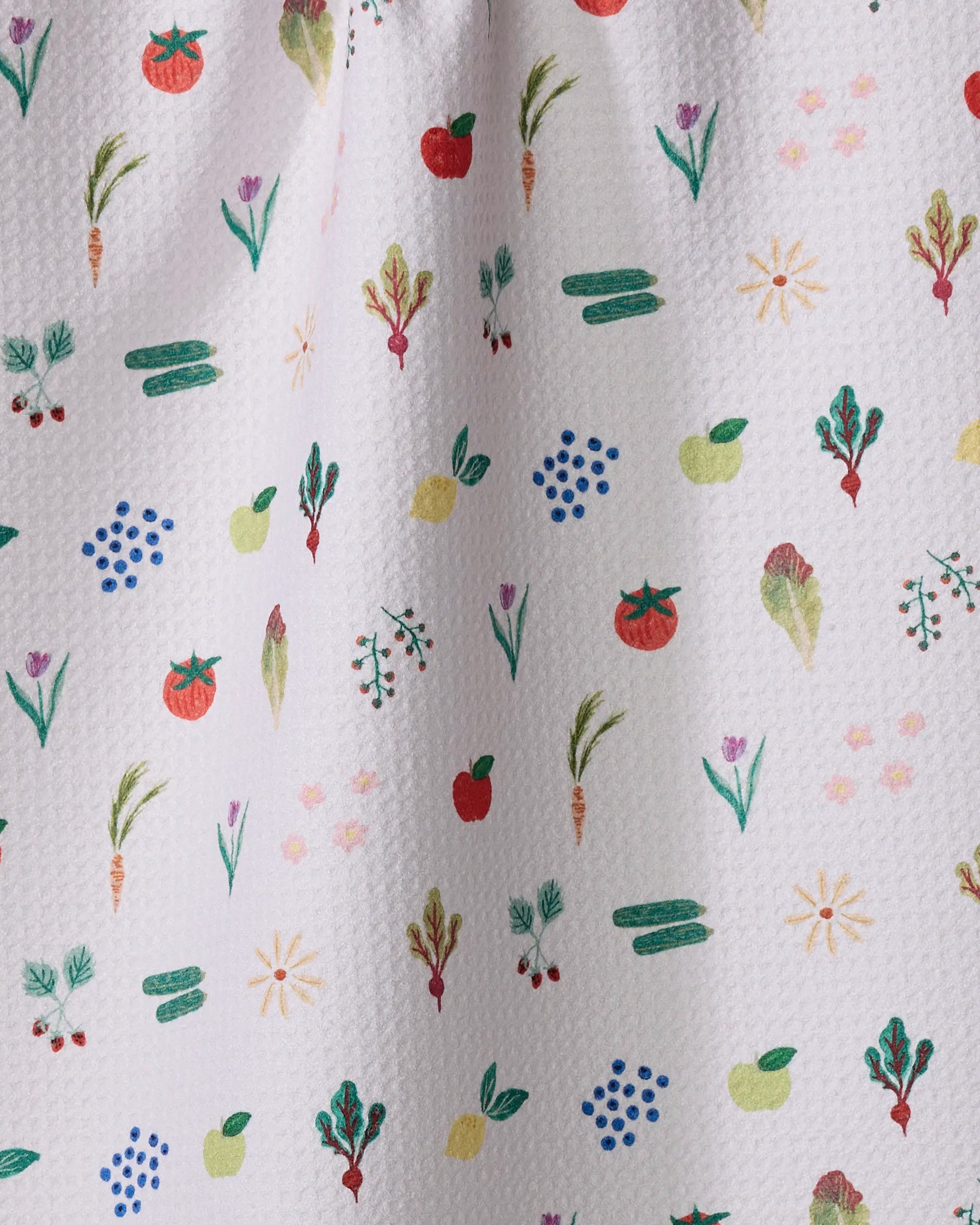 The "Fresh Produce" tea towel by Brittany Jepsen features a white textured design with colorful, hand-drawn fruits and veggies like apples, tomatoes, carrots, and cucumbers—perfect for adding charm to any kitchen.