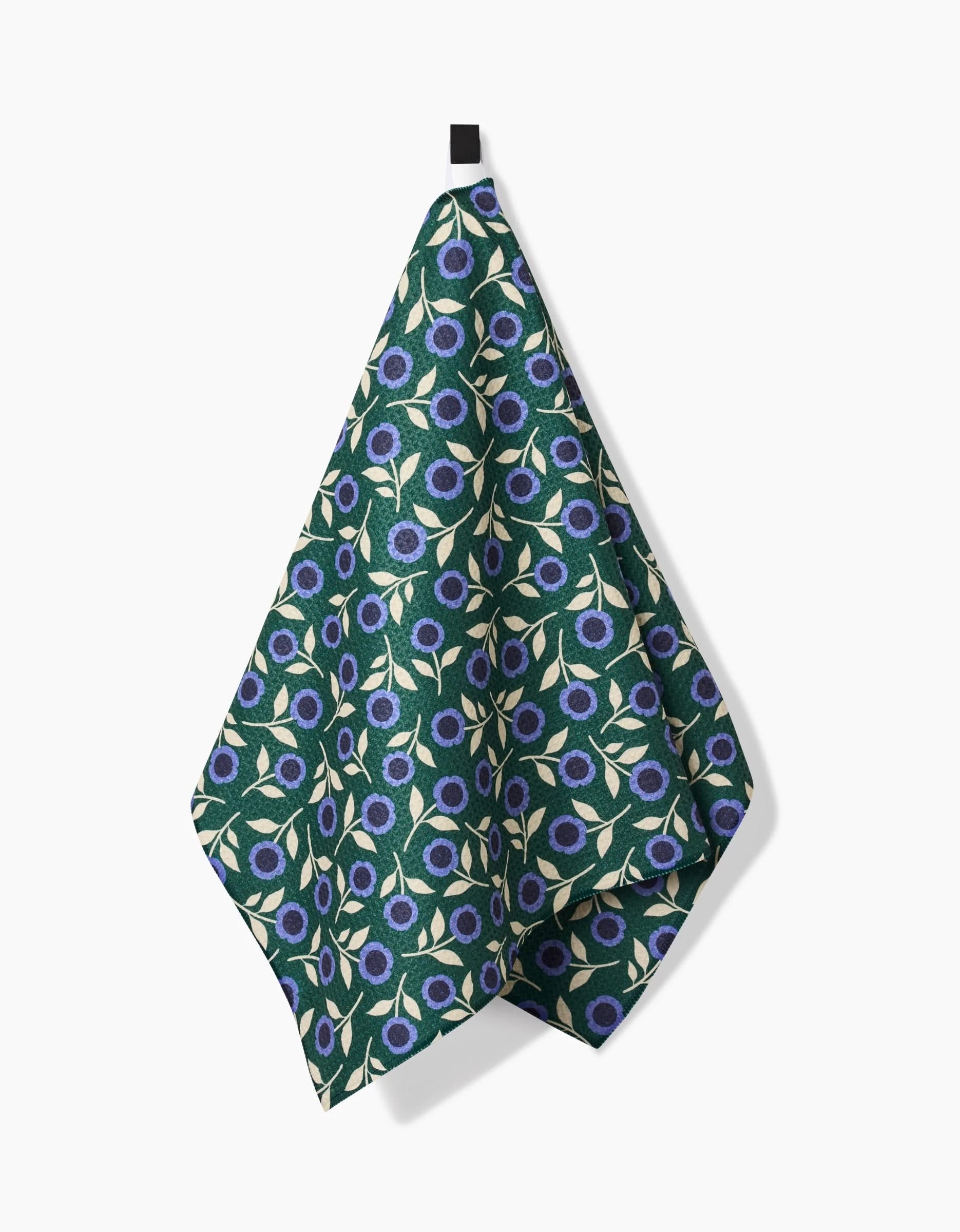 The Megan Kampa Friendly Floral Blue tea towel, made from recycled materials, showcases a blue floral pattern with green leaves and hangs from a small black loop against a white background.