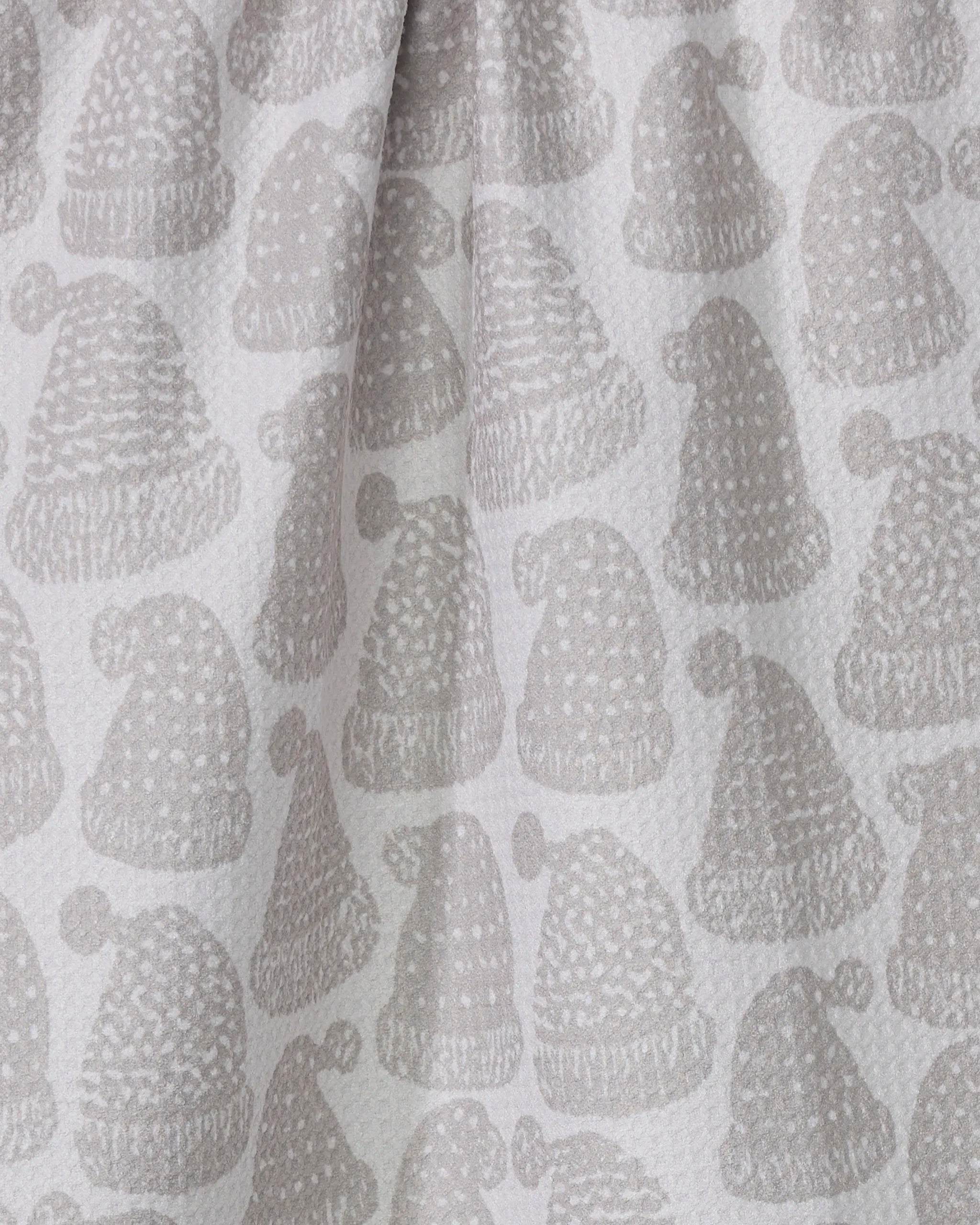 The Geometry Frostcap tea towel features a repeating pattern of light grey winter hats with pom-poms on a white background. Ultra-absorbent with a soft, textured surface, it makes a stylish and practical addition to any kitchen.