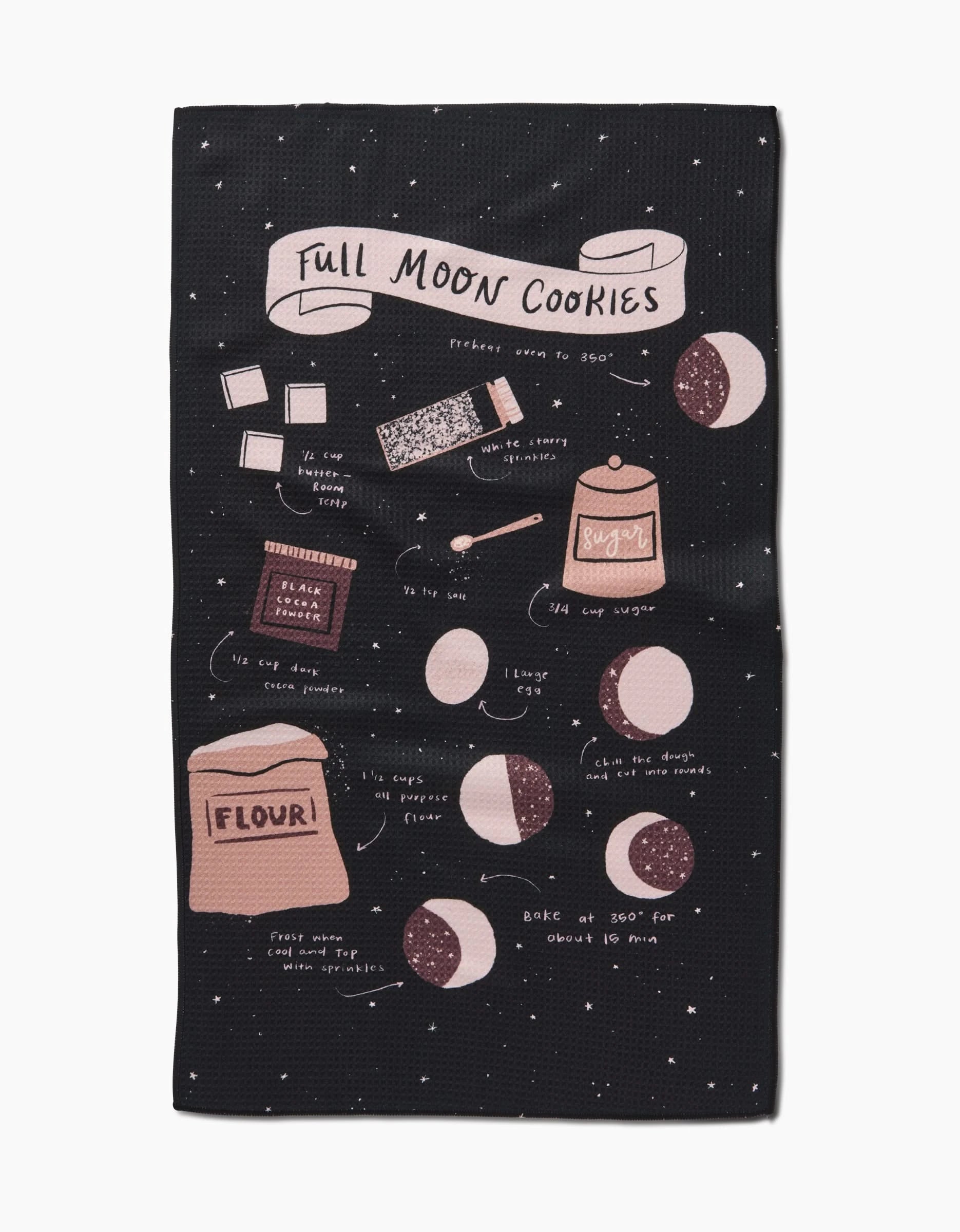 The Janna Sue Design Full Moon Cookies black dish towel features an illustrated cookie recipe with drawings of flour, sugar, eggs, cocoa, cookie phases, and baking instructions in white and pink text.