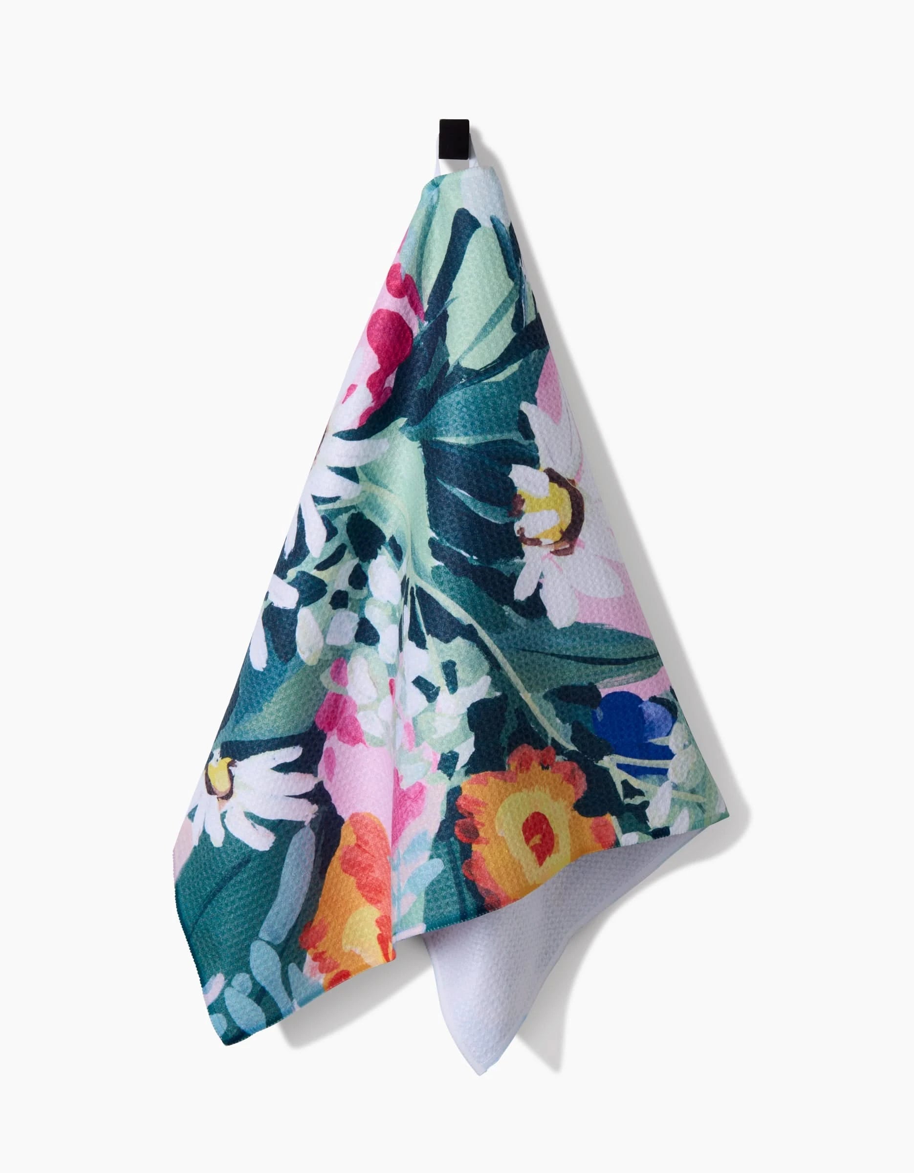 The Garden Bouquet tea towel by Ania Zwara Art features a vibrant floral pattern with daisies in green, pink, orange, and white on ultra-absorbent Geoweave fabric. It hangs from a black loop for style and function.