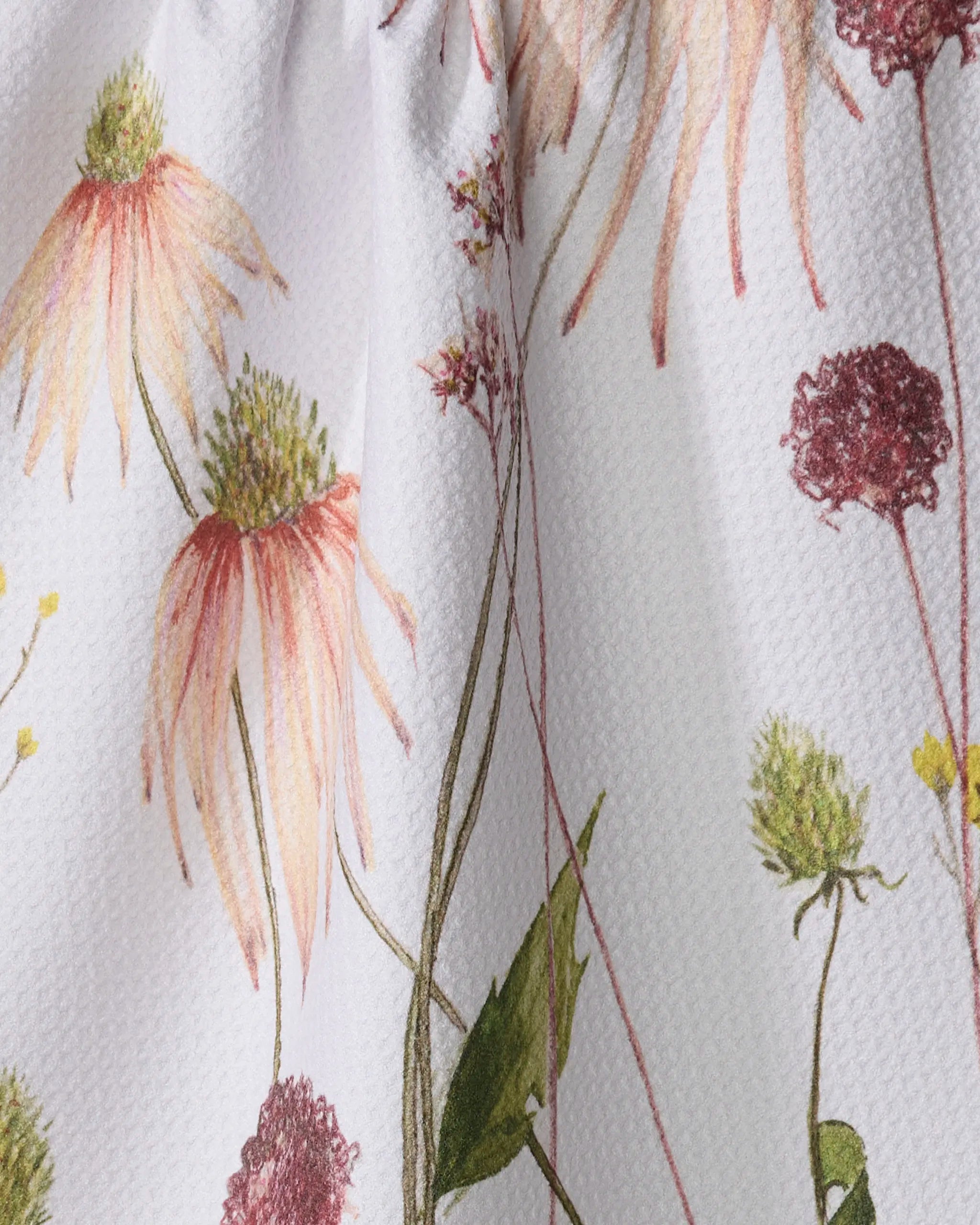 The Elana Gabrielle "Garden Flowers" dish towel features a textured white background with pink, yellow, and burgundy wildflowers and green stems in a colorful floral print.