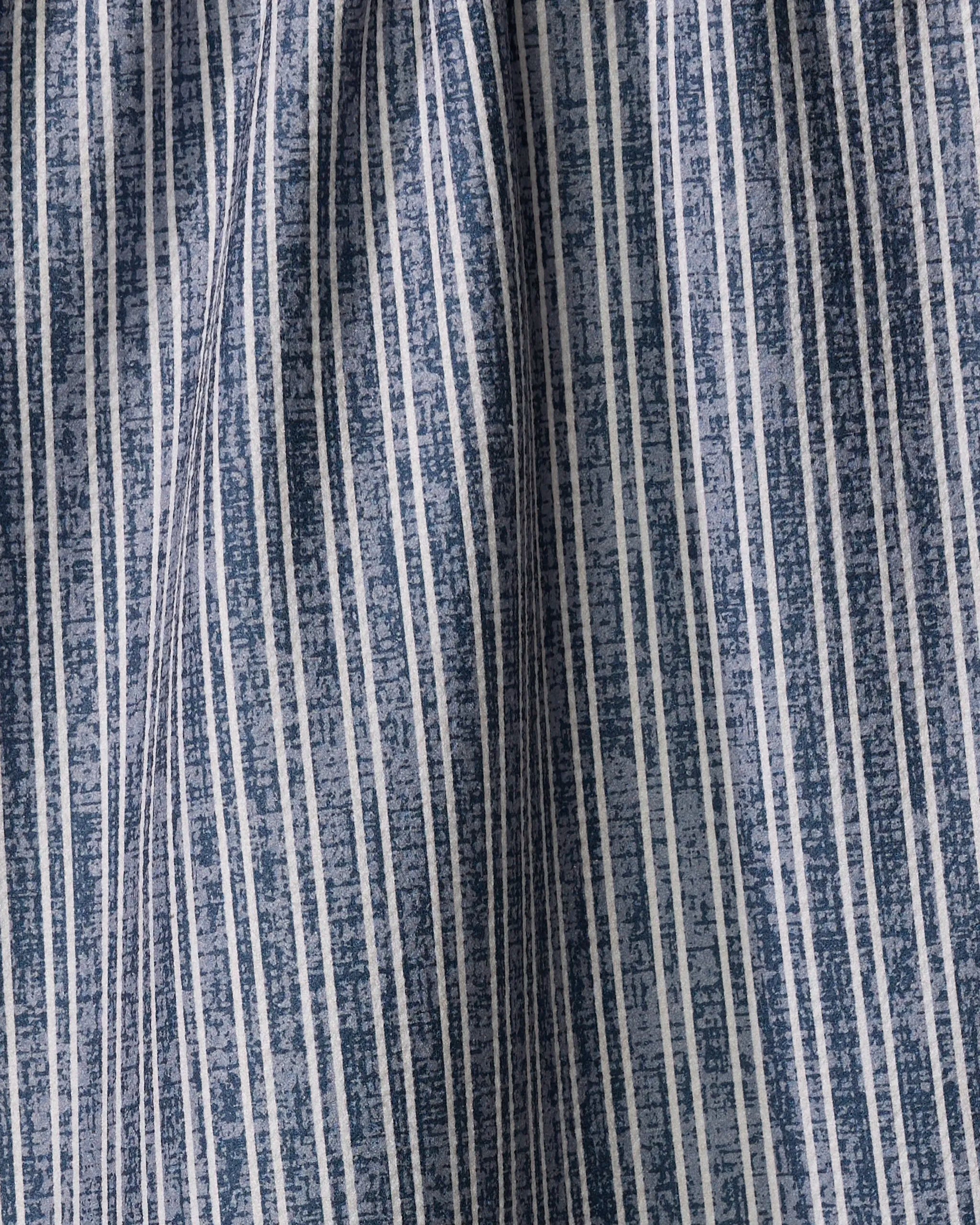 Close-up of the Garff Blue tea towel by Becki Owens, featuring blue and white vertical stripes with a subtle textured surface and gentle folds creating soft shadows.
