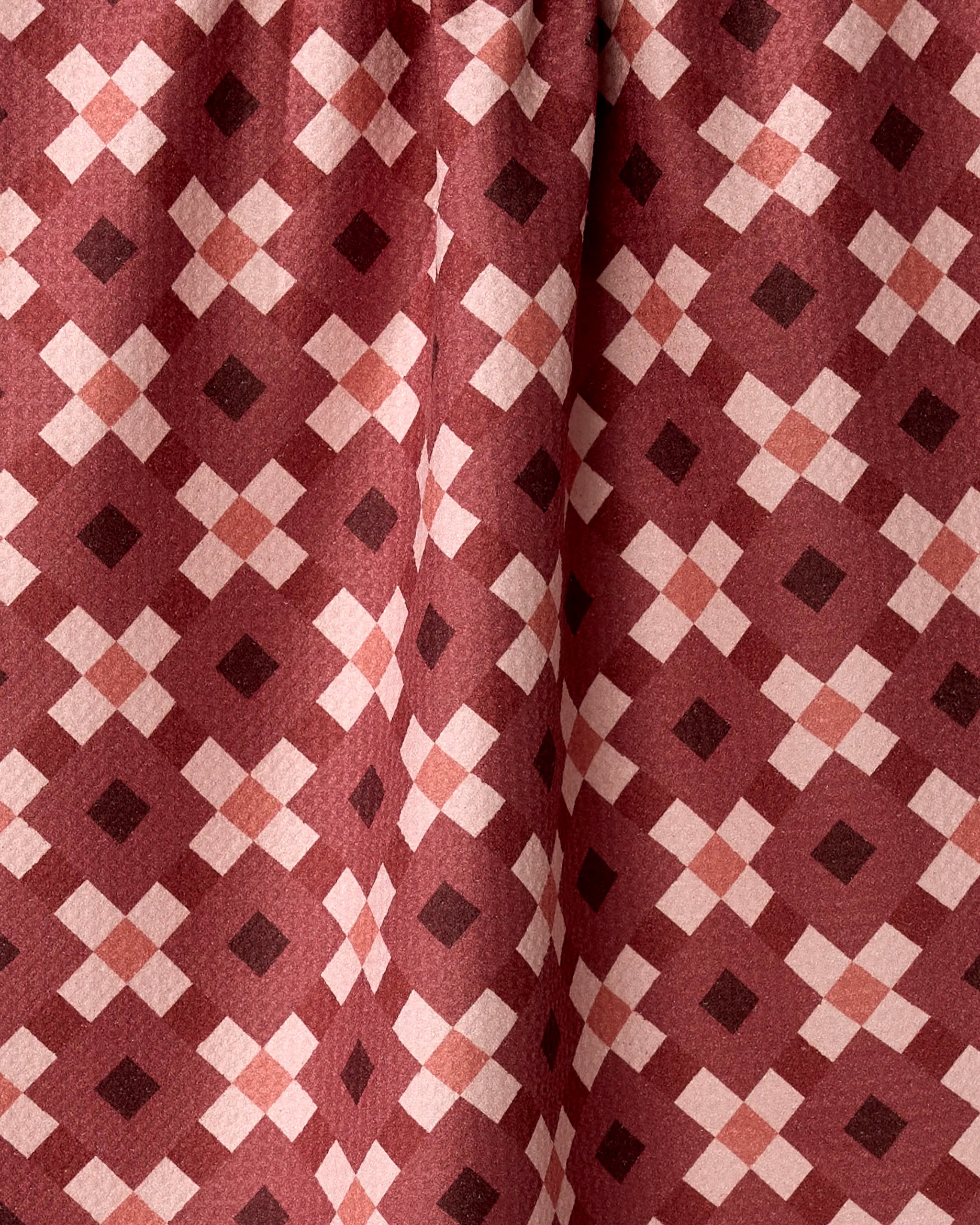 The Garnet Geo by Teri the Butter is a maroon fabric tea towel featuring a symmetrical geometric pattern of light pink and dark red diamonds, made from recycled materials.