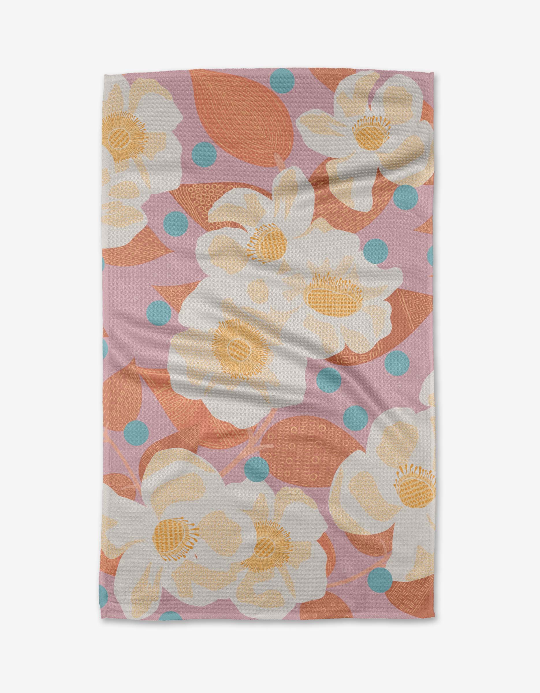 The Georgia Rose towel by Julianne Haness features ultra-absorbent Geoweave fabric with large white and yellow flowers, orange leaves, and light blue dots on a pink background, shown flat with slight wrinkles.