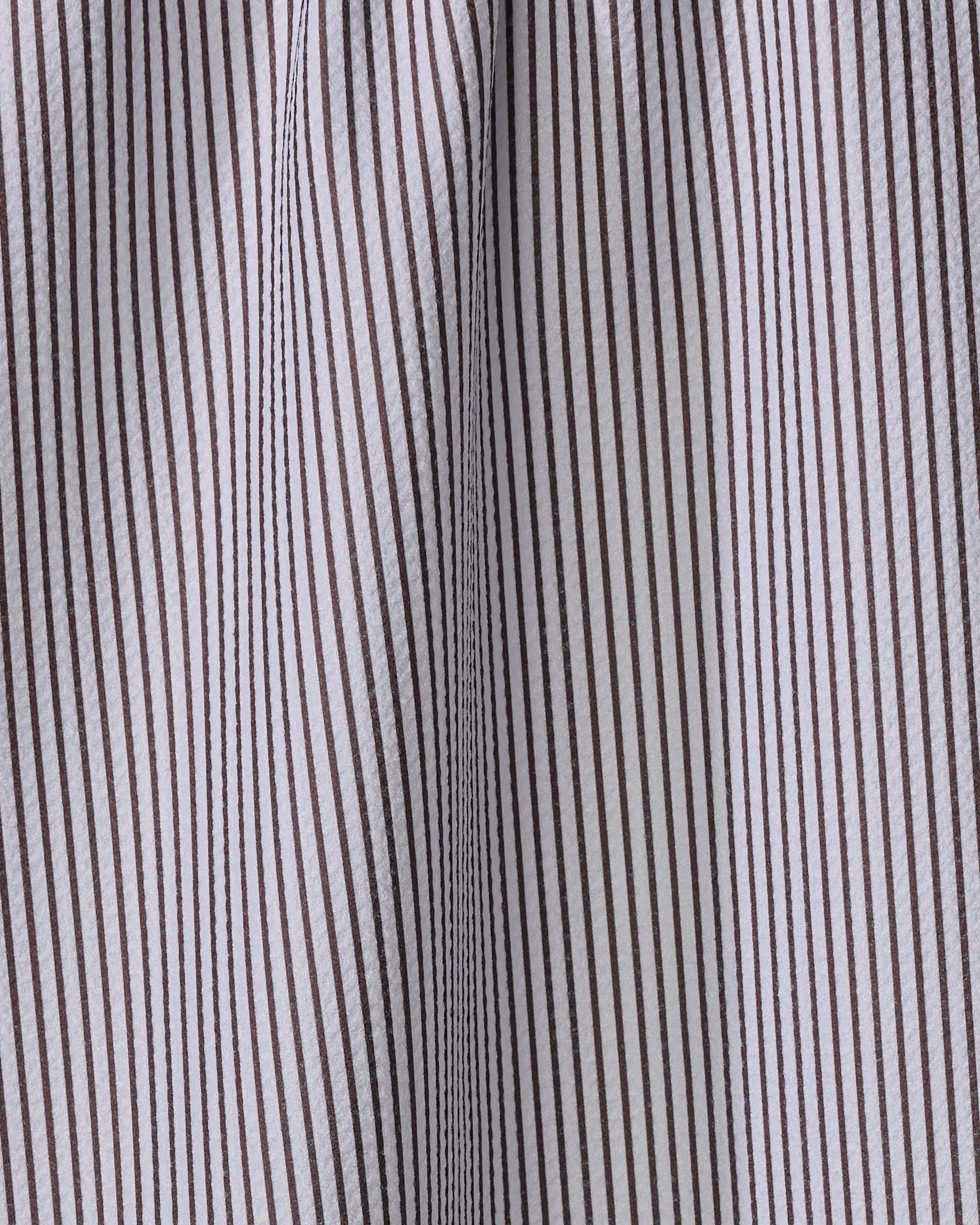 Close-up of The Buy Guide’s Get In Line - Chocolate kitchen tea towel with vertical brown and white pinstripes. Visible texture, seams, and gentle folds highlight its eco-friendly design crafted from recycled materials.