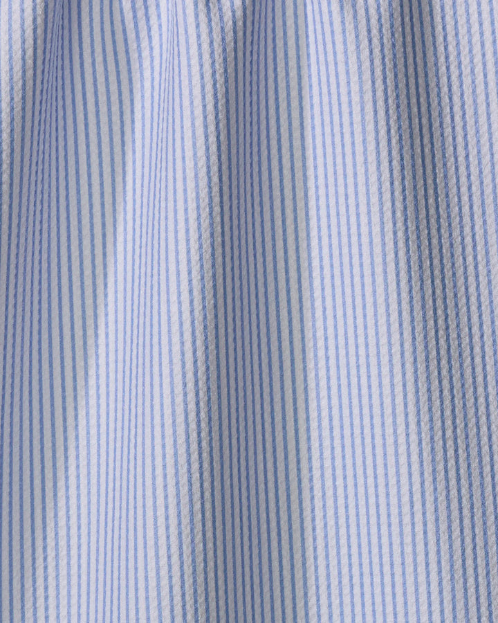 Close-up of French blue and white vertical pinstripes on textured cotton fabric from The Buy Guide’s Get In Line tea towel. Soft folds and shadows highlight the ultra-absorbent material and quality craftsmanship.