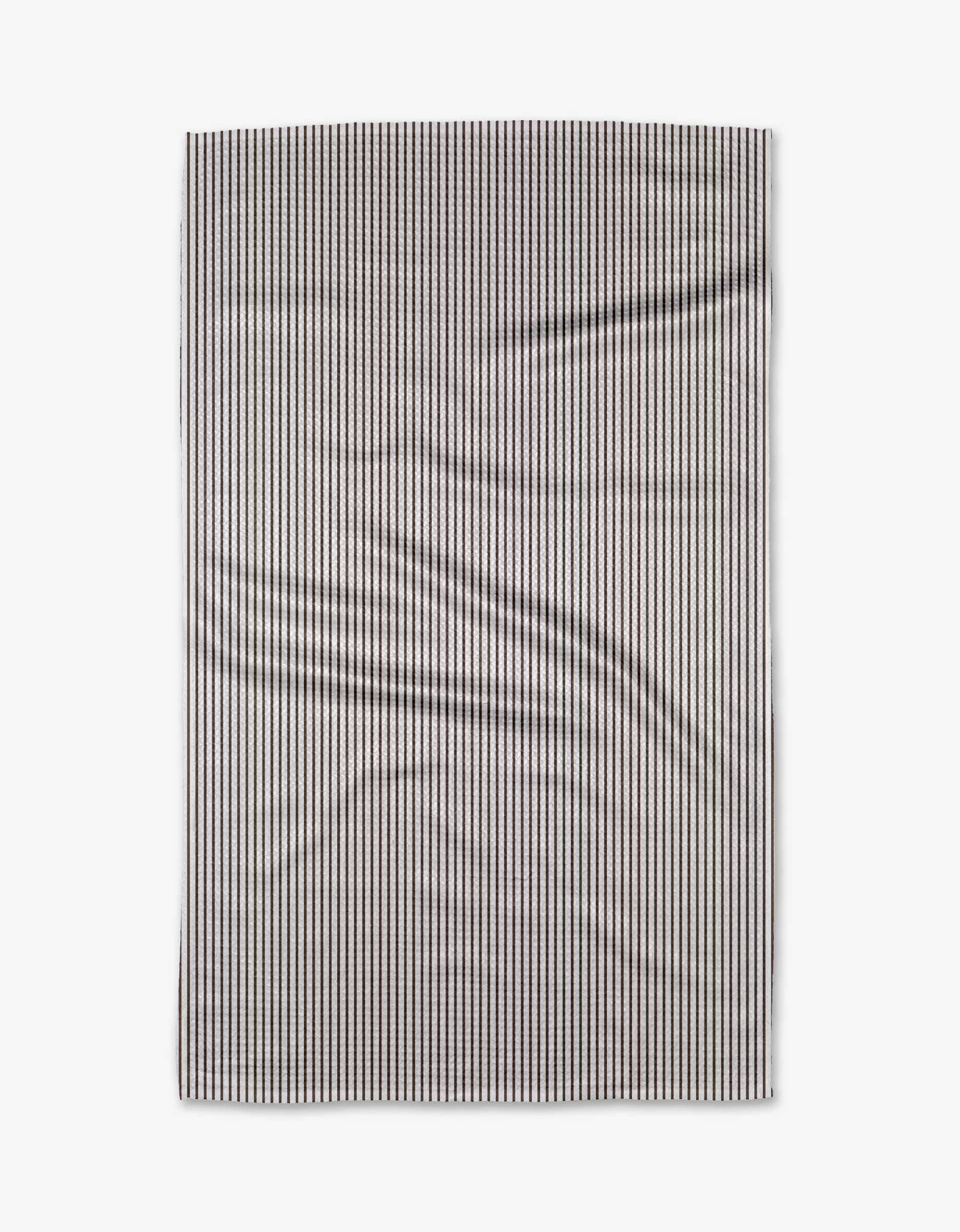 The Buy Guides Get In Line - Chocolate Tea Towel, featuring narrow vertical black and white stripes on Geoweave™ fabric, is displayed flat with visible folds and creases against a plain light background.