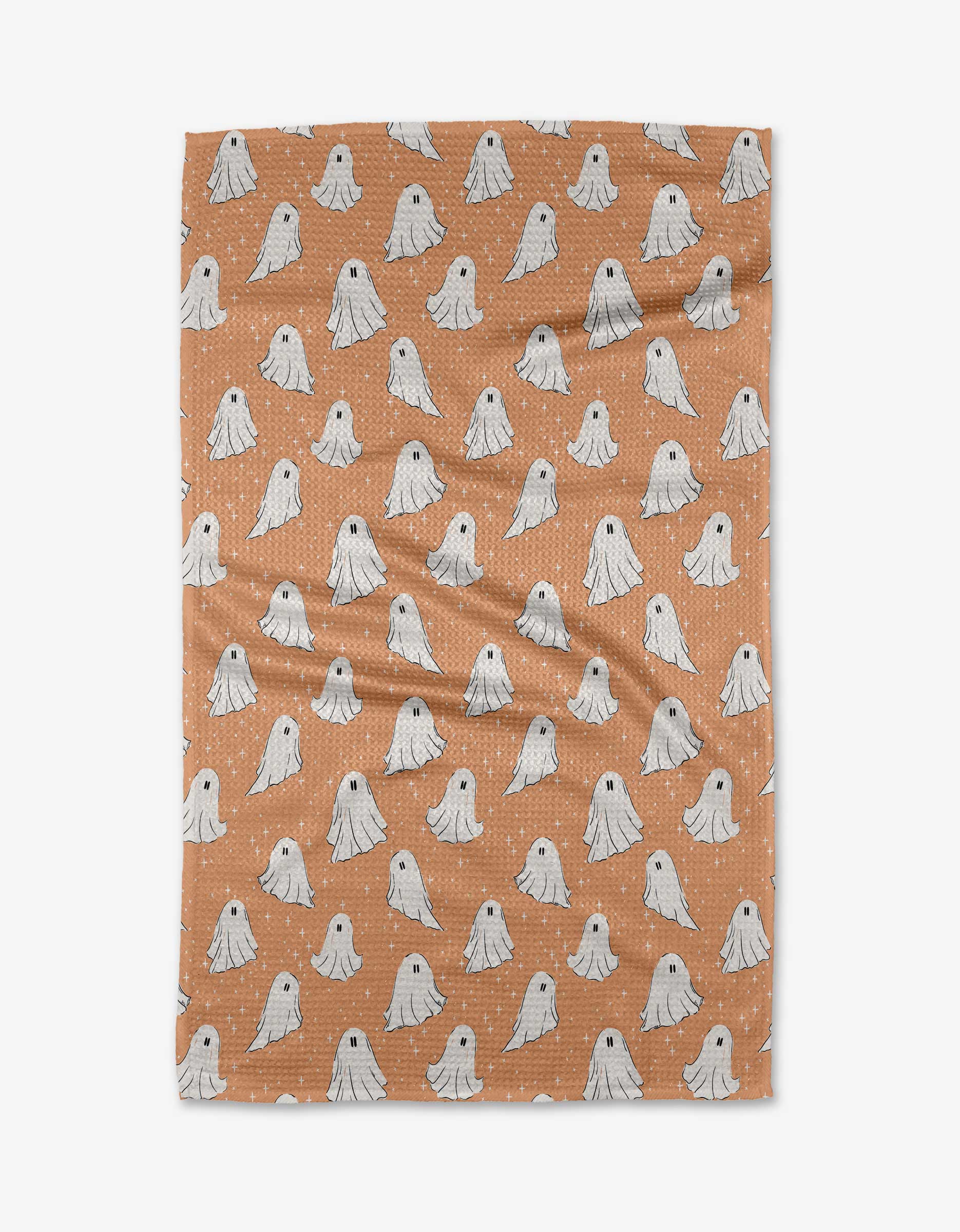 The Ghosts In The Night tea towel by Charlie Rowan Designs features rows of small, white cartoon ghosts on brown, and is crafted from ultra-absorbent recycled materials for eco-friendly charm and functionality.