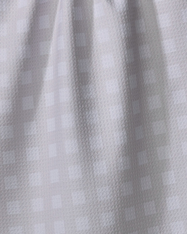 A close-up of Gigi - Beige by The Buy Guide, featuring light beige recycled fabric with a subtle checkered pattern and gently textured surface—ideal as a kitchen towel, displayed with soft vertical folds.