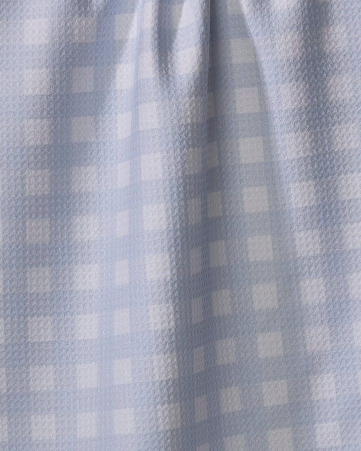 The Gigi - Light Blue dish towel by The Buy Guide features light blue and white checkered fabric with a subtle texture, soft folds, and absorbent material that creates gentle shadows and highlights across the surface.